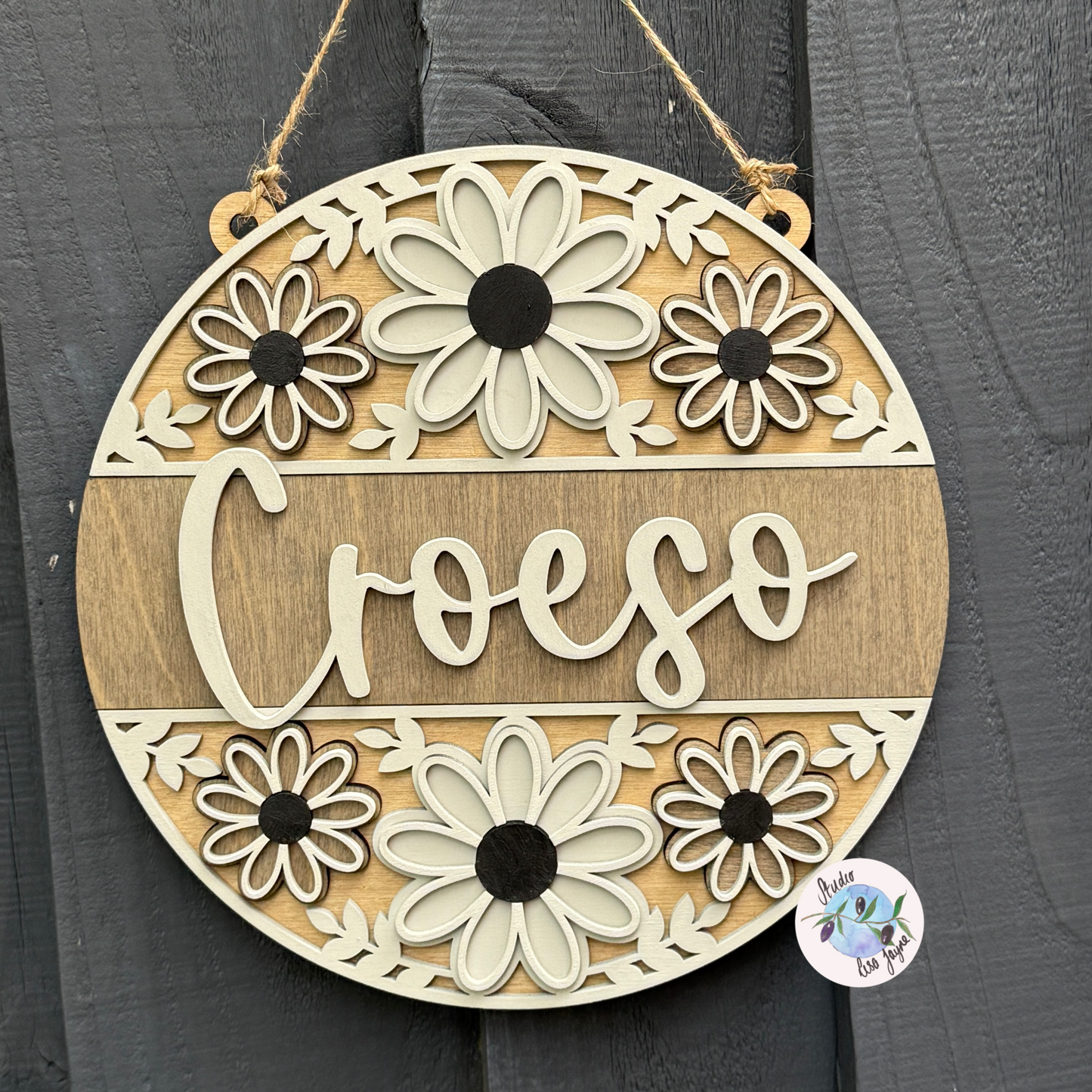 Welcome/Croeso Floral Handmade Hanging Wooden Sign - Grey wood stain centre with cream and dark grey chalk paint flowers
In a simple gray backdground