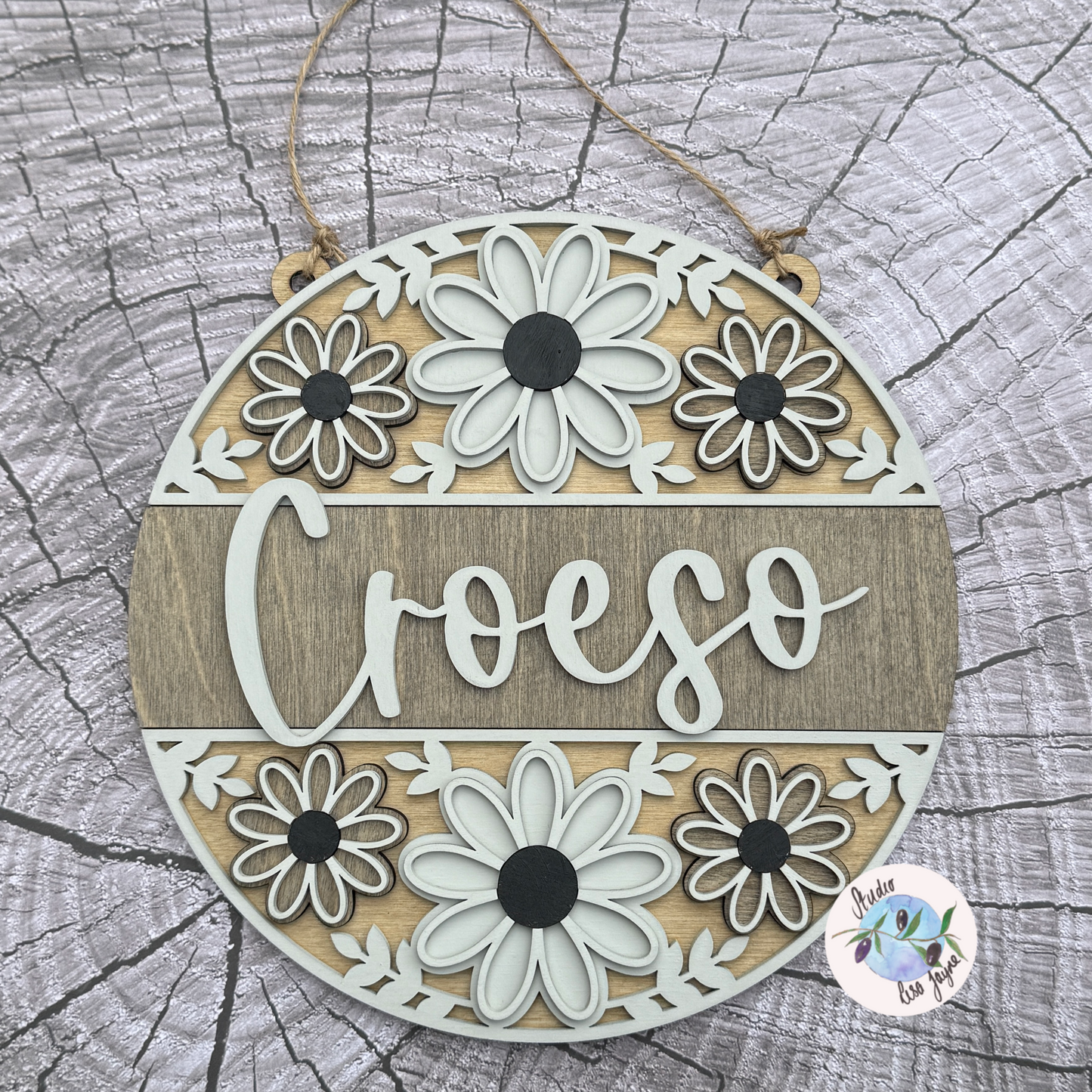Welcome/Croeso Floral Handmade Hanging Wooden Sign - Grey wood stain centre with cream and dark grey chalk paint flower. On a simple wood stump background