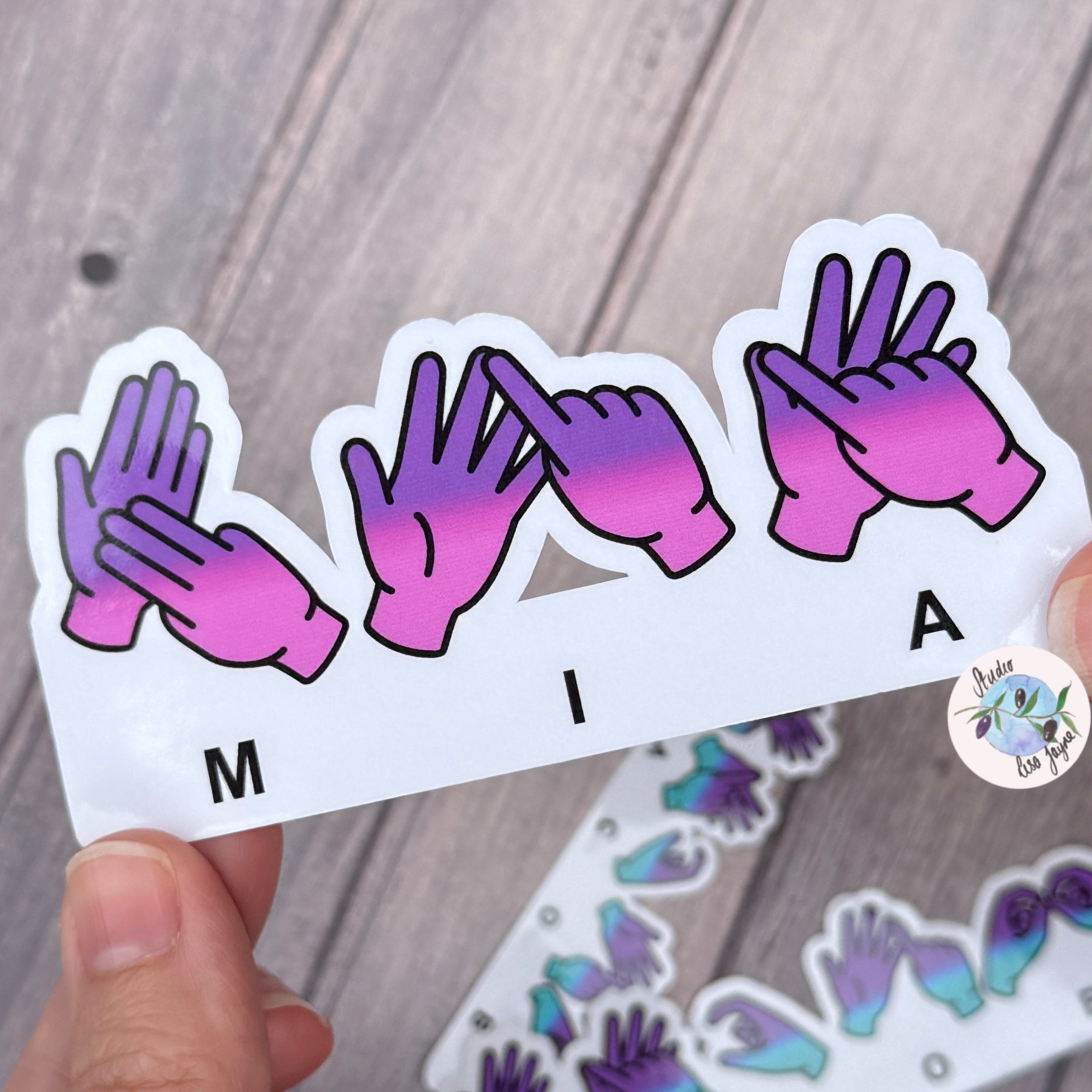 Gradient sticker with hands forming letters 'M', 'I', 'A' spelt in. BSL British Sign Laguage