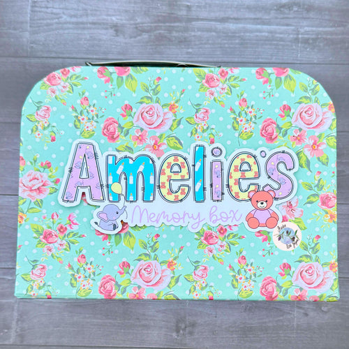Floral-patterned keepsake chest with 'Amelies' and 'memory box' text with a new baby theme and a teddy and elephant with a baloon