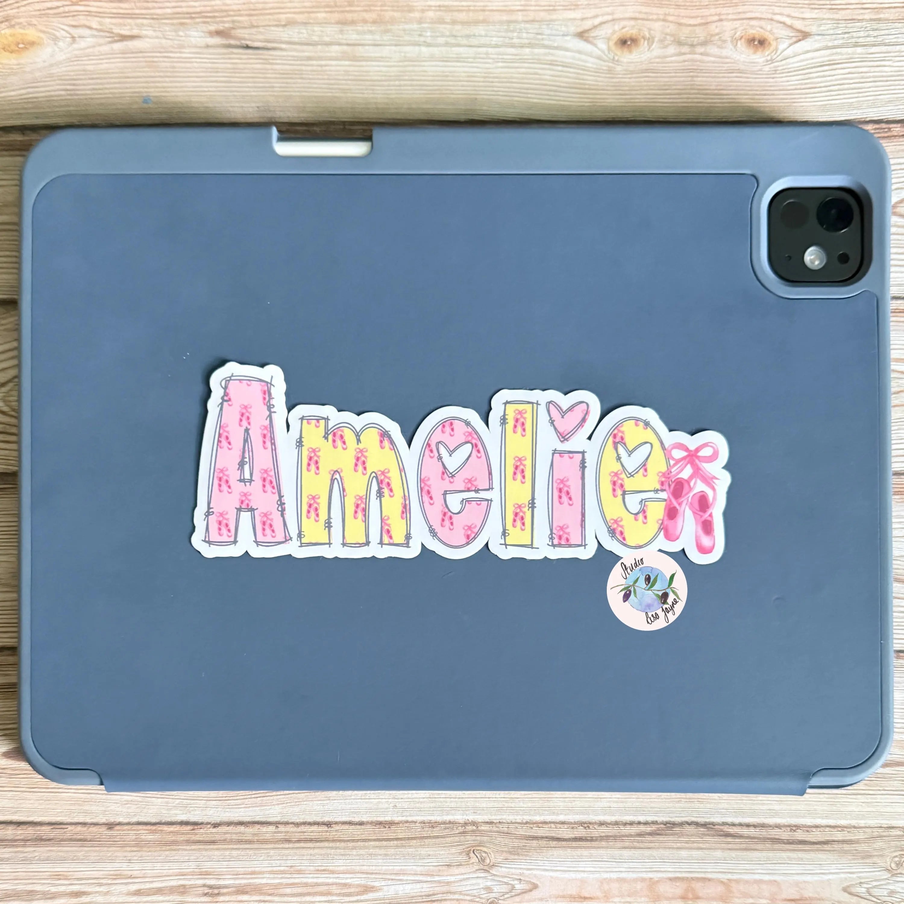 Blue iPad tablet case with 'Amelie' ballet themed name sticker with pink and yellow colorful letters