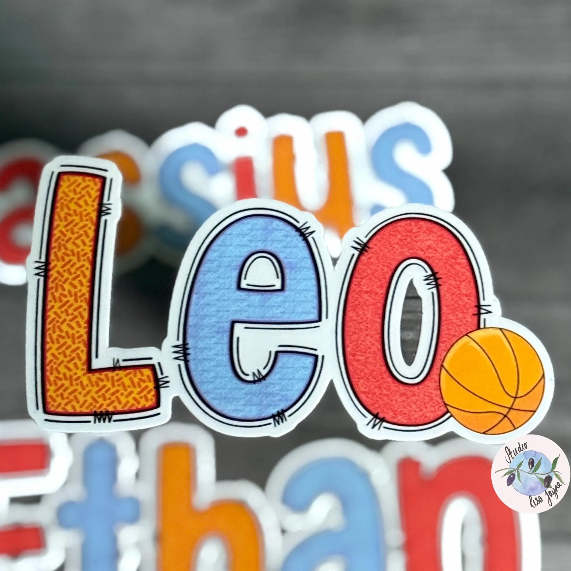 Colourful letter stickers spelling 'Leo' with a basketball graphic on a grey background
