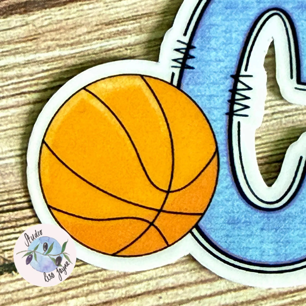 Basketball sticker with letter 'C' on a wooden surface