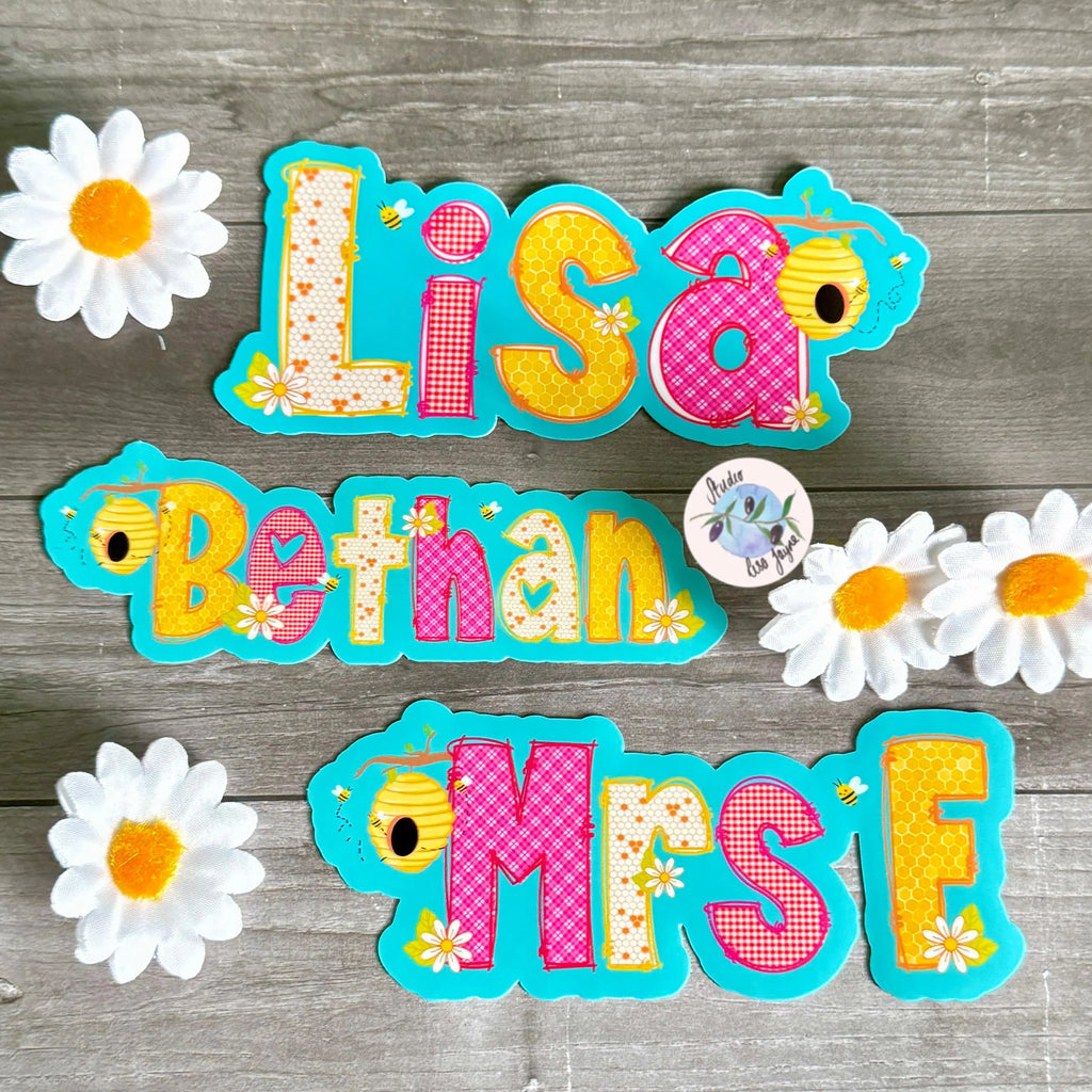 Colorful Summer, Picnic and Bee name decals for Lisa, Bethan, and Mrs F on a wooden surface with daisies.