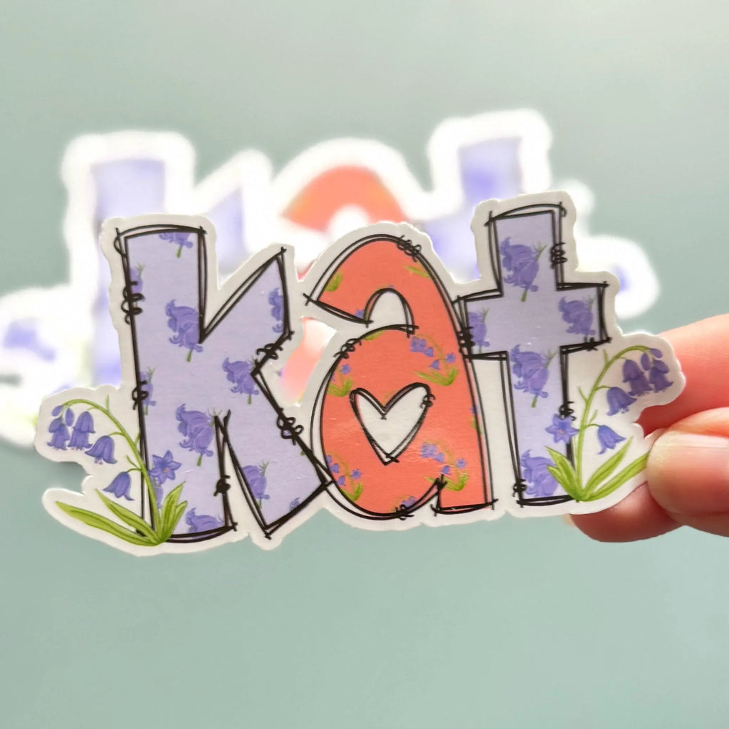 Bluebell Sticker with 'Kat' design held by a hand against a light background
