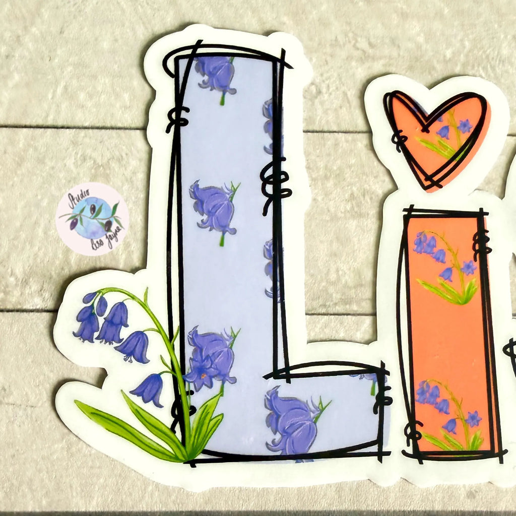 Decorative letter 'L' with floral Bluebell design on a textured surface