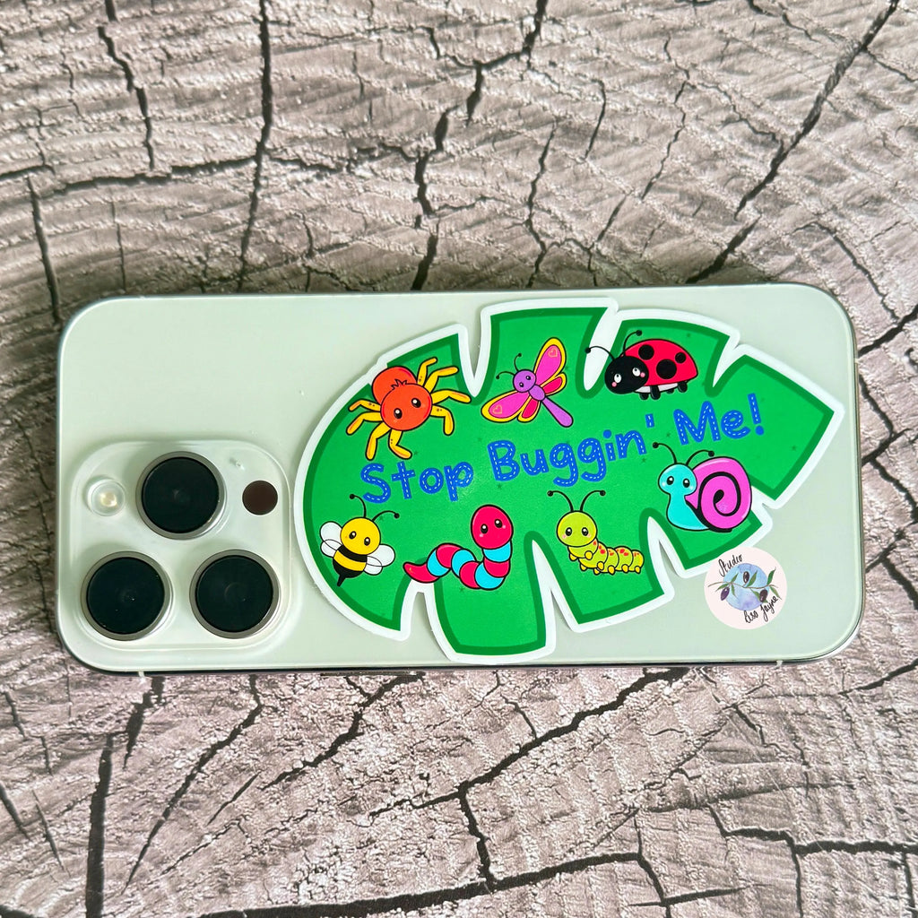 Phone with cartoon bugs design sticker on a wooden surface
