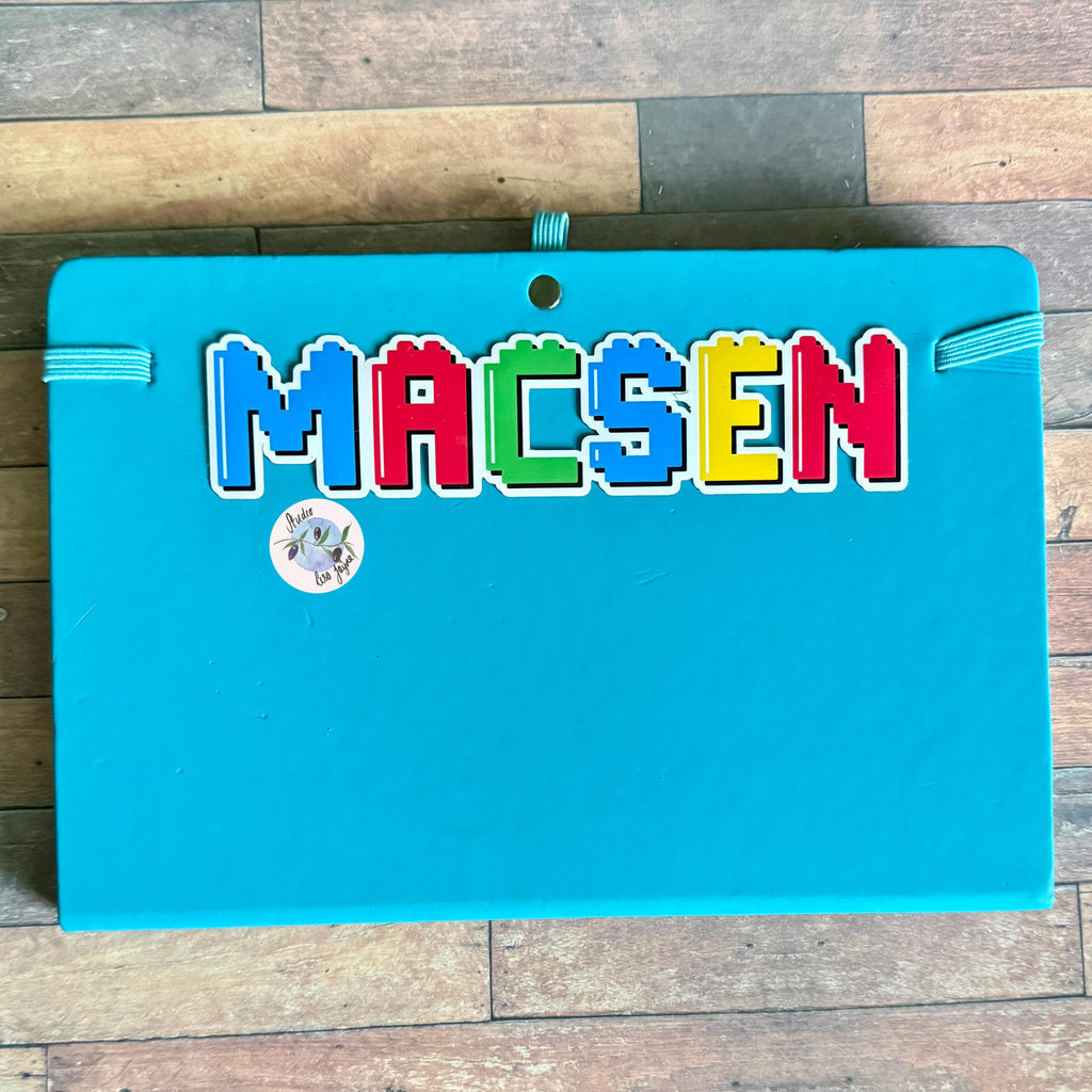 Blue diary notebook with colourful building blocks style letters spelling 'MACSEN' ideal for master builder children