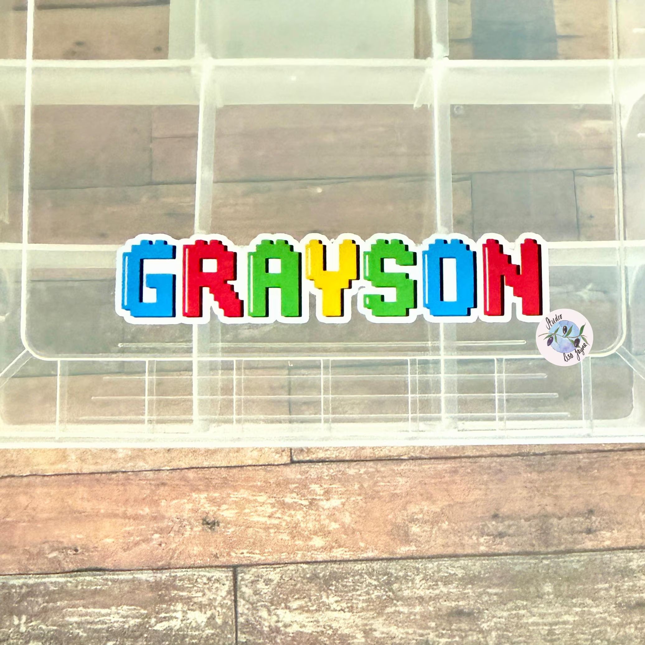 Colourful name 'GRAYSON' on a transparent container for storing sweets and other treats