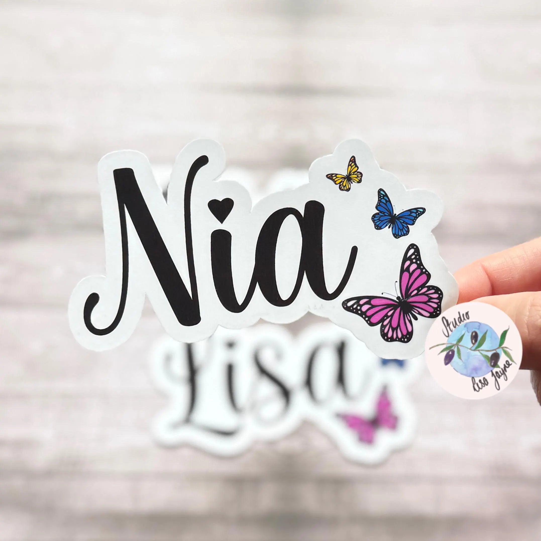 Sticker with 'Nia' text and colourful butterfly designs
