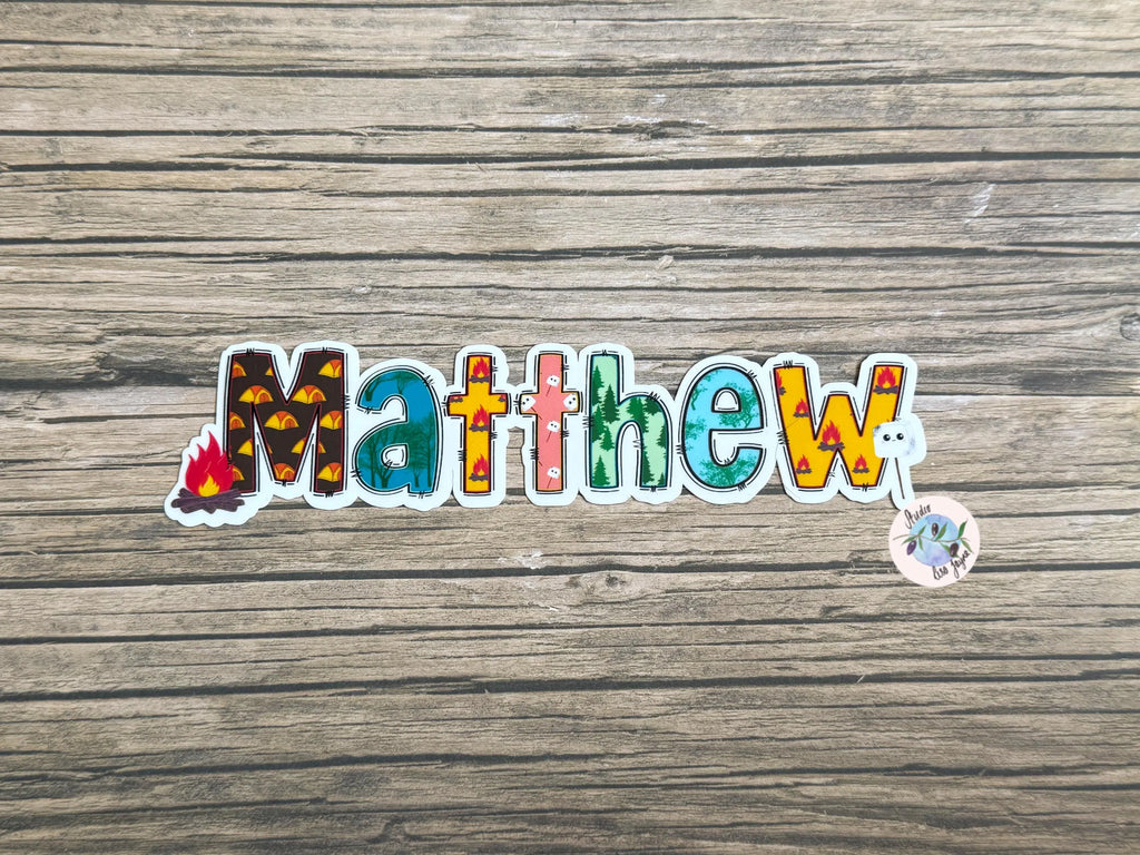 Colorful sticker with the name 'Matthew' on a wooden surface