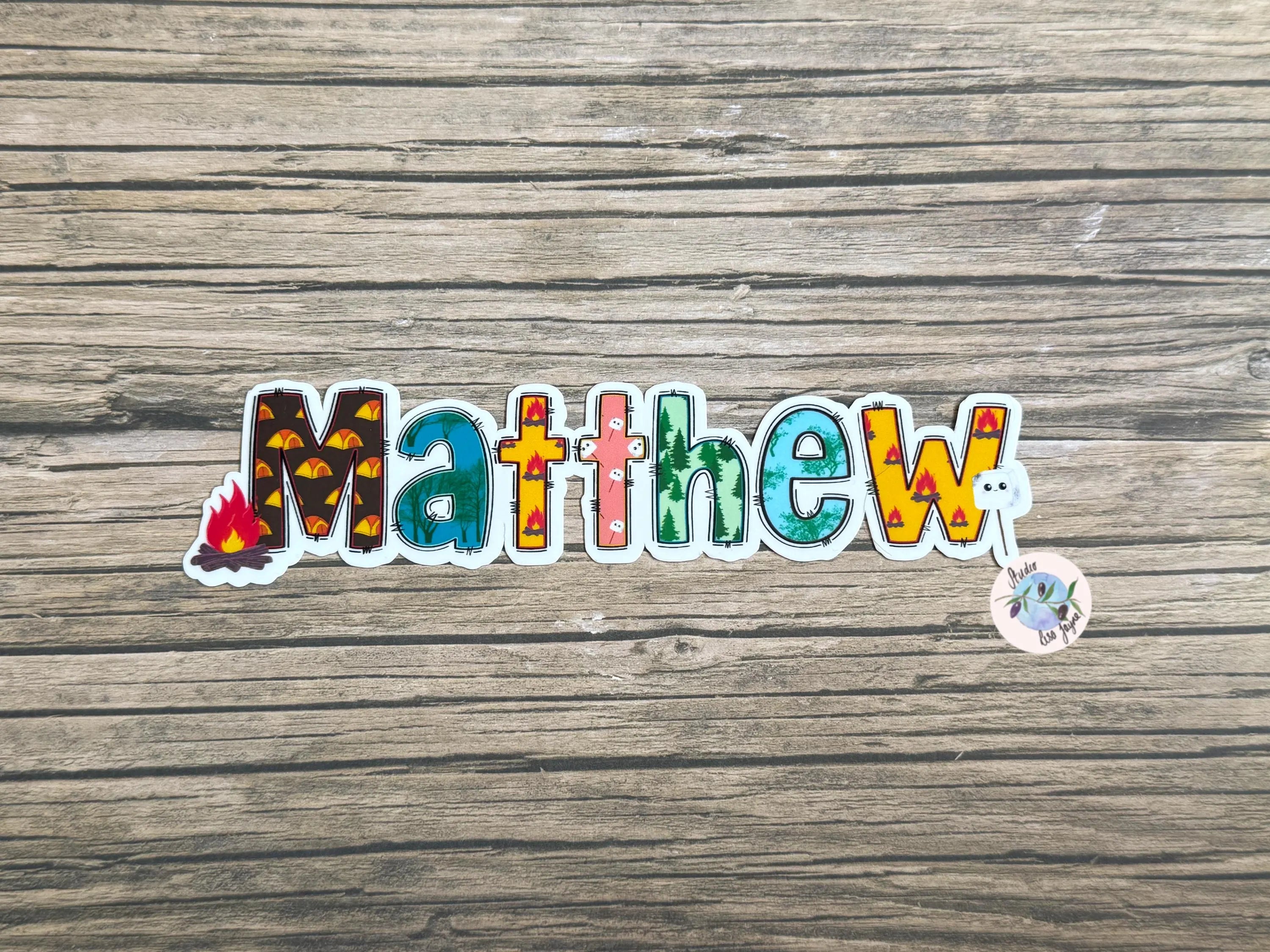 Colorful sticker with the name 'Matthew' on a wooden surface