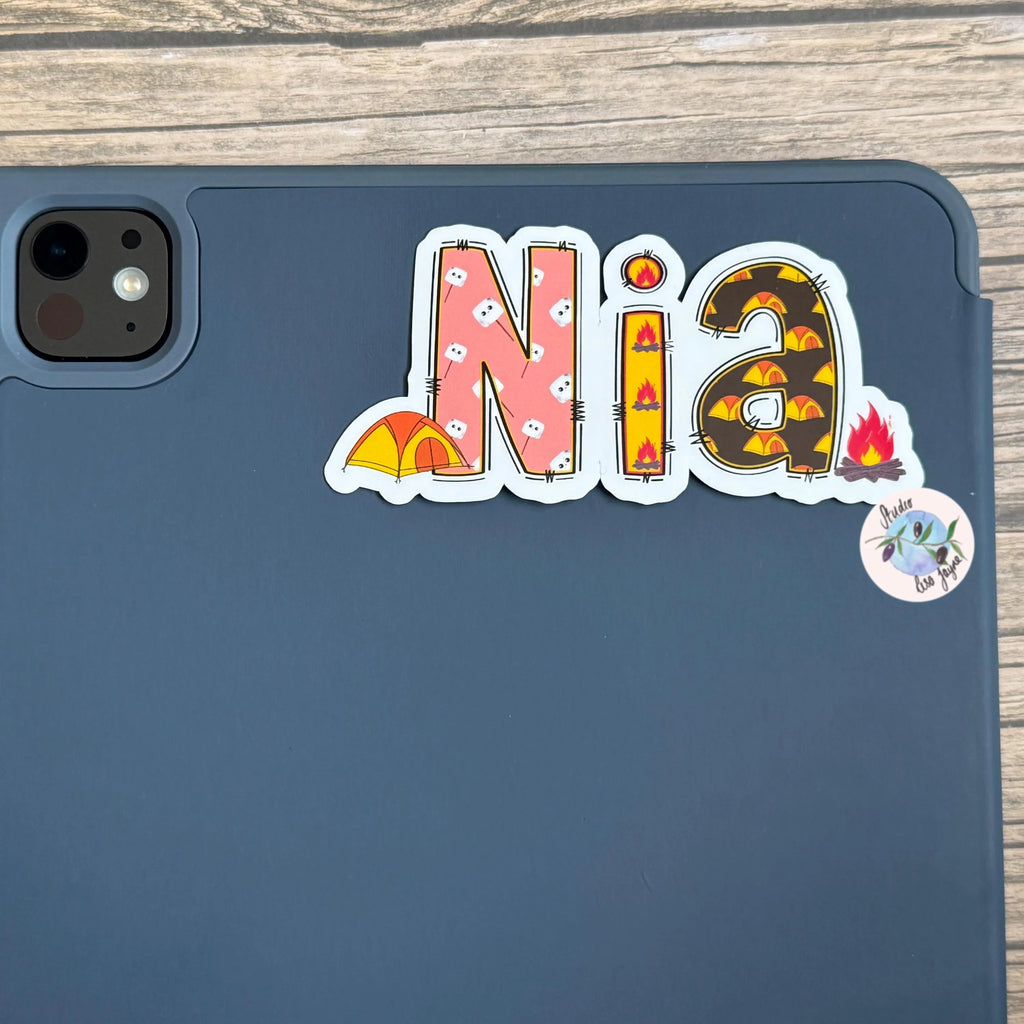 iPad tablet case with 'Nia' camping themed vinyl decal sticker on a wooden surface
