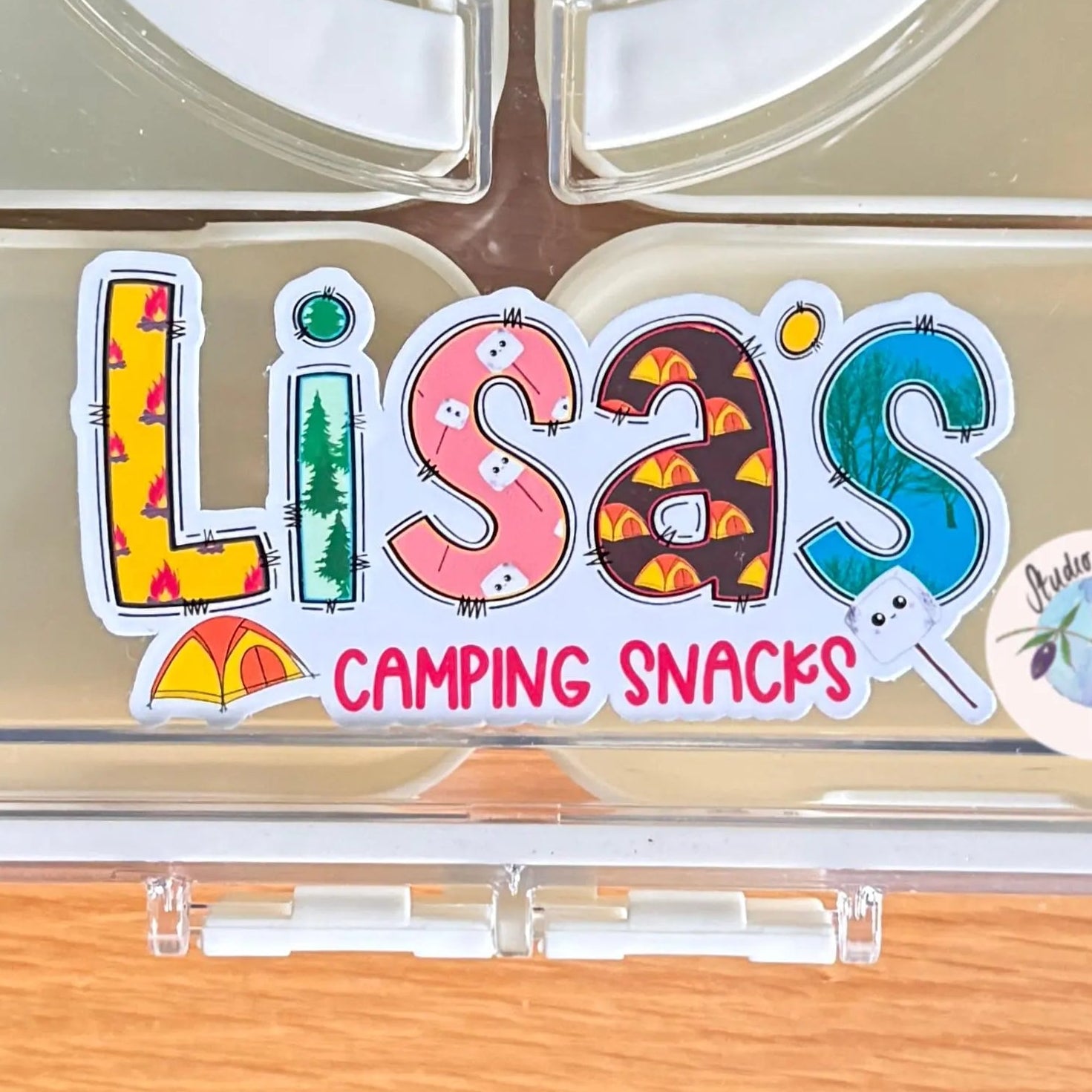 Clear compartmentalized container with 'Lisa's Camping Snacks' personalised camping label