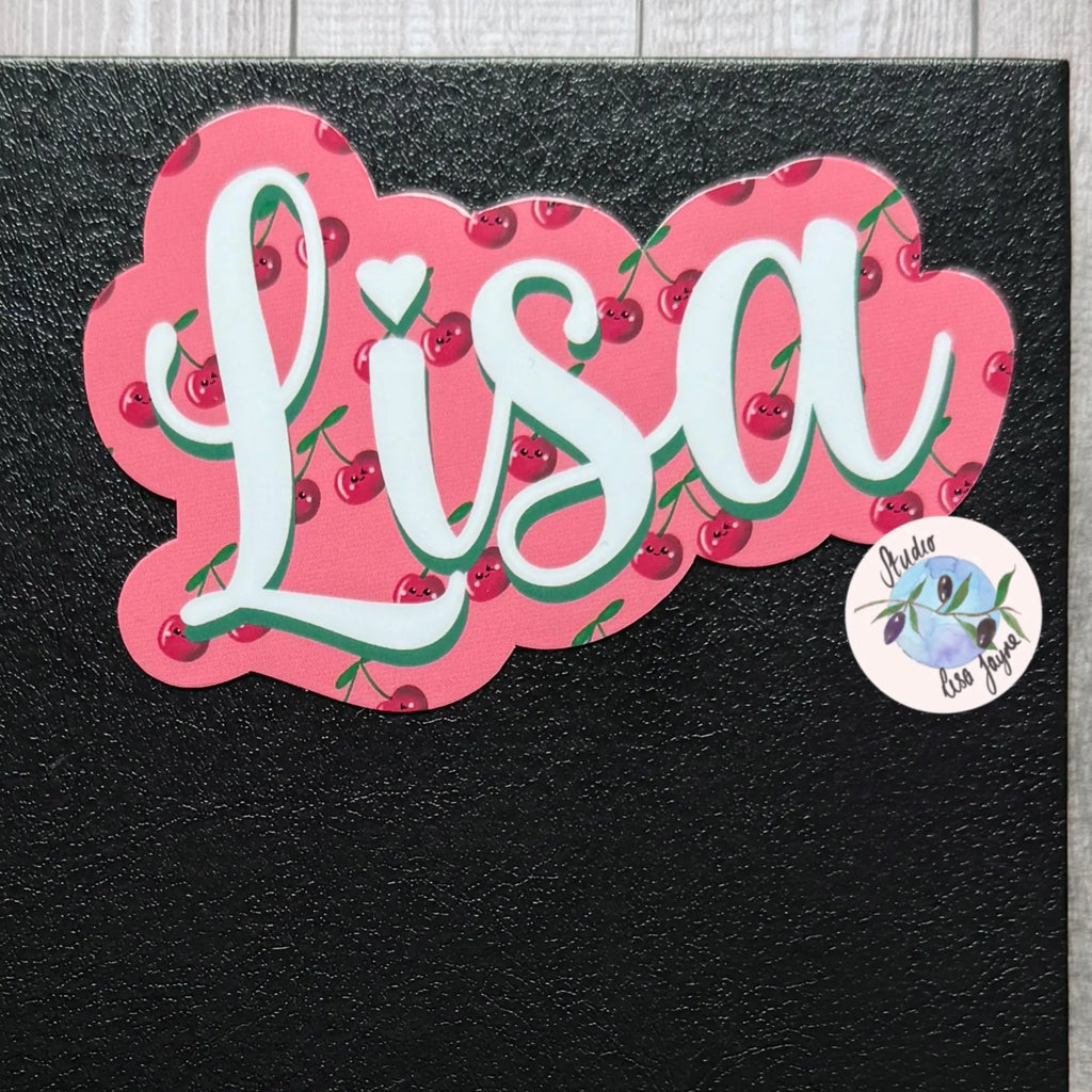 Sticker with the name 'Lisa' surrounded by cherries on a black background