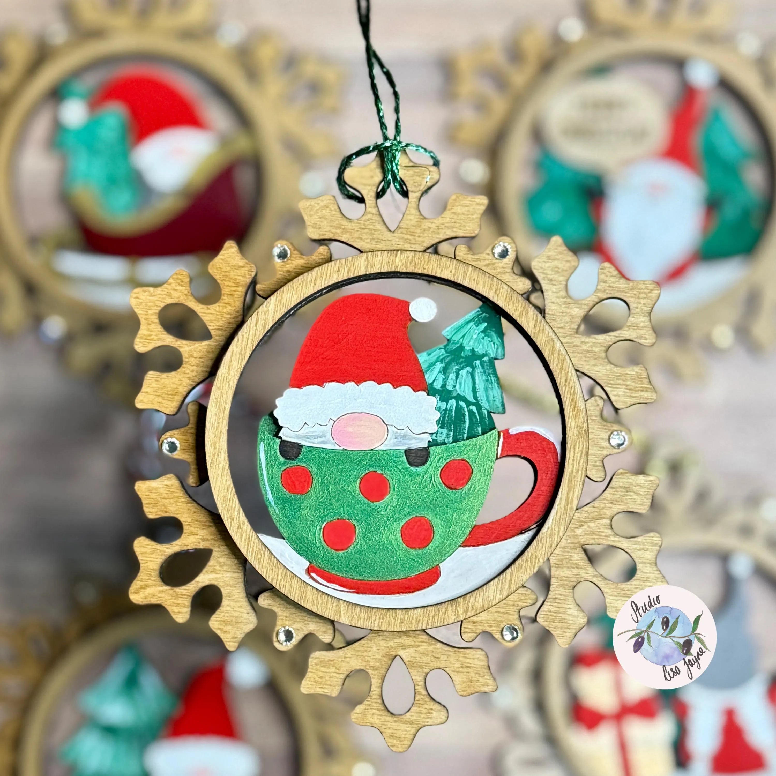 Handmade handpainted Christmas ornament with a gnome in a teacup design, surrounded by other similar ornaments.