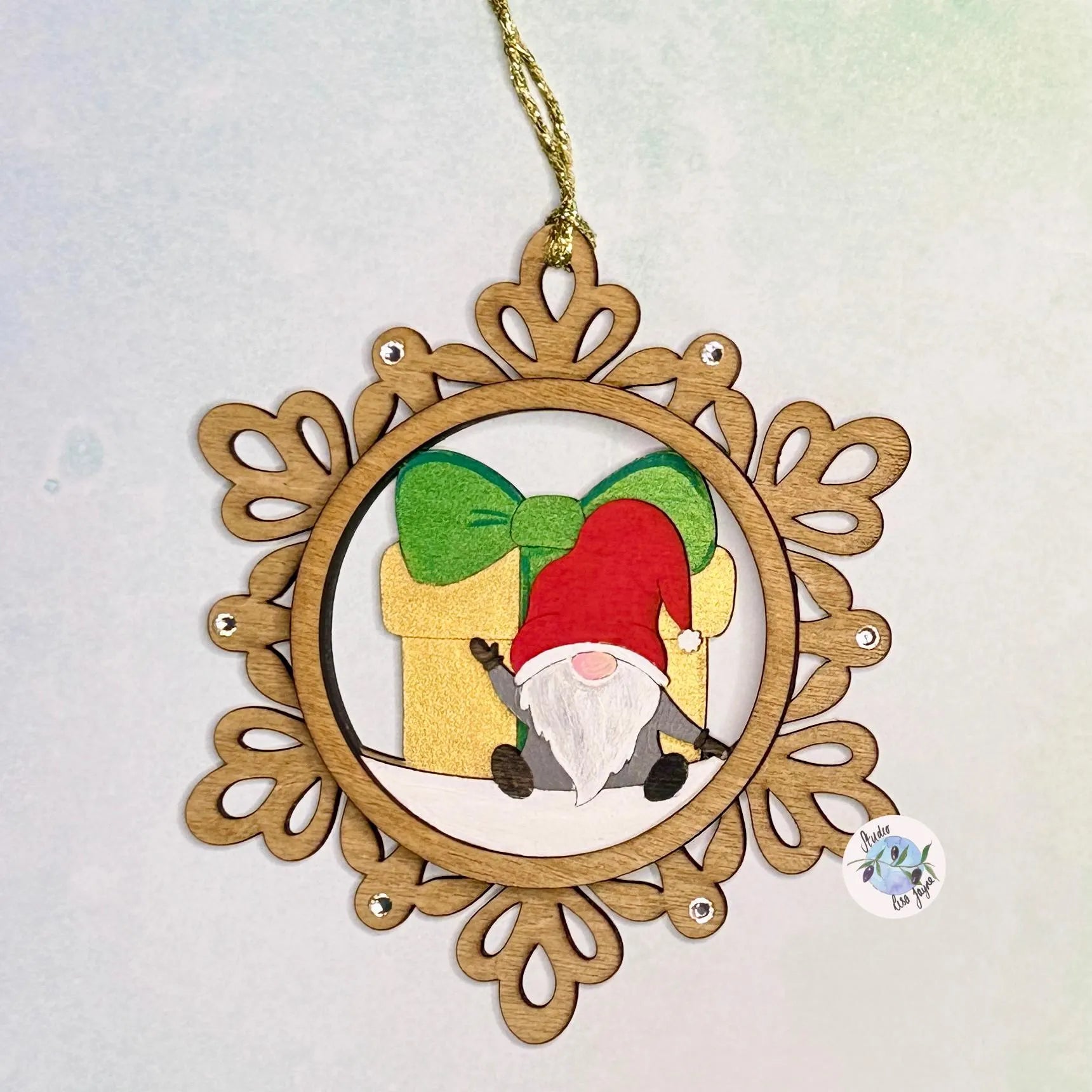 Decorative ornament with a gnome and gift in a wooden frame on a light background