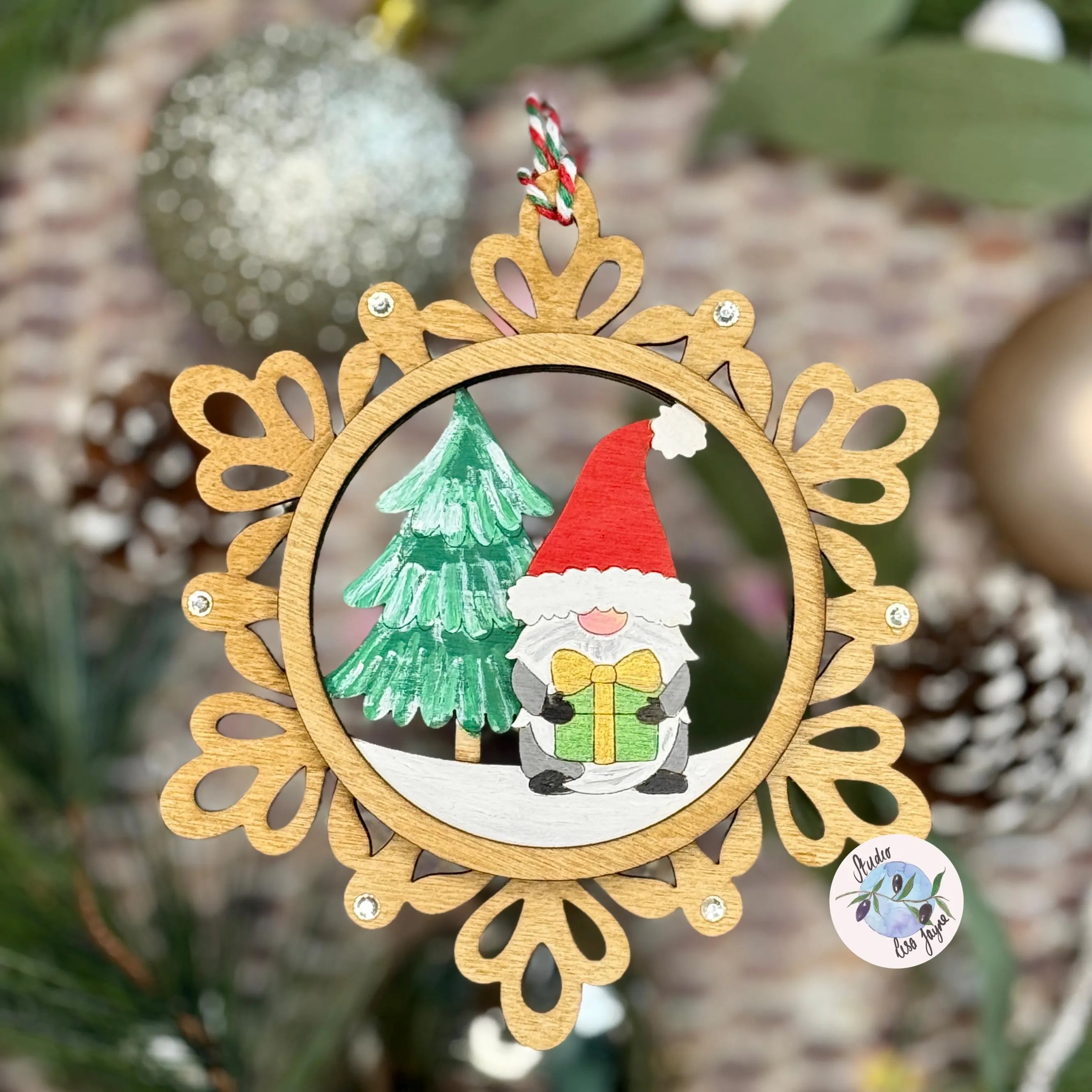 Decorative Christmas ornament with a gnome and tree design, surrounded by festive decorations.