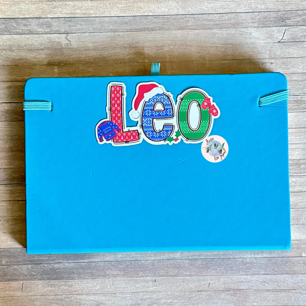 Blue photo albumn with 'Leo' name on a wooden surface