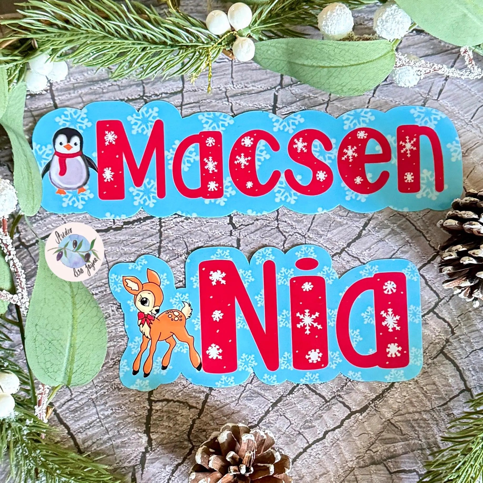 Children's name stickers with Christmas-themed graphics on a wooden surface.  Option of a cute deer or fluffy penguin