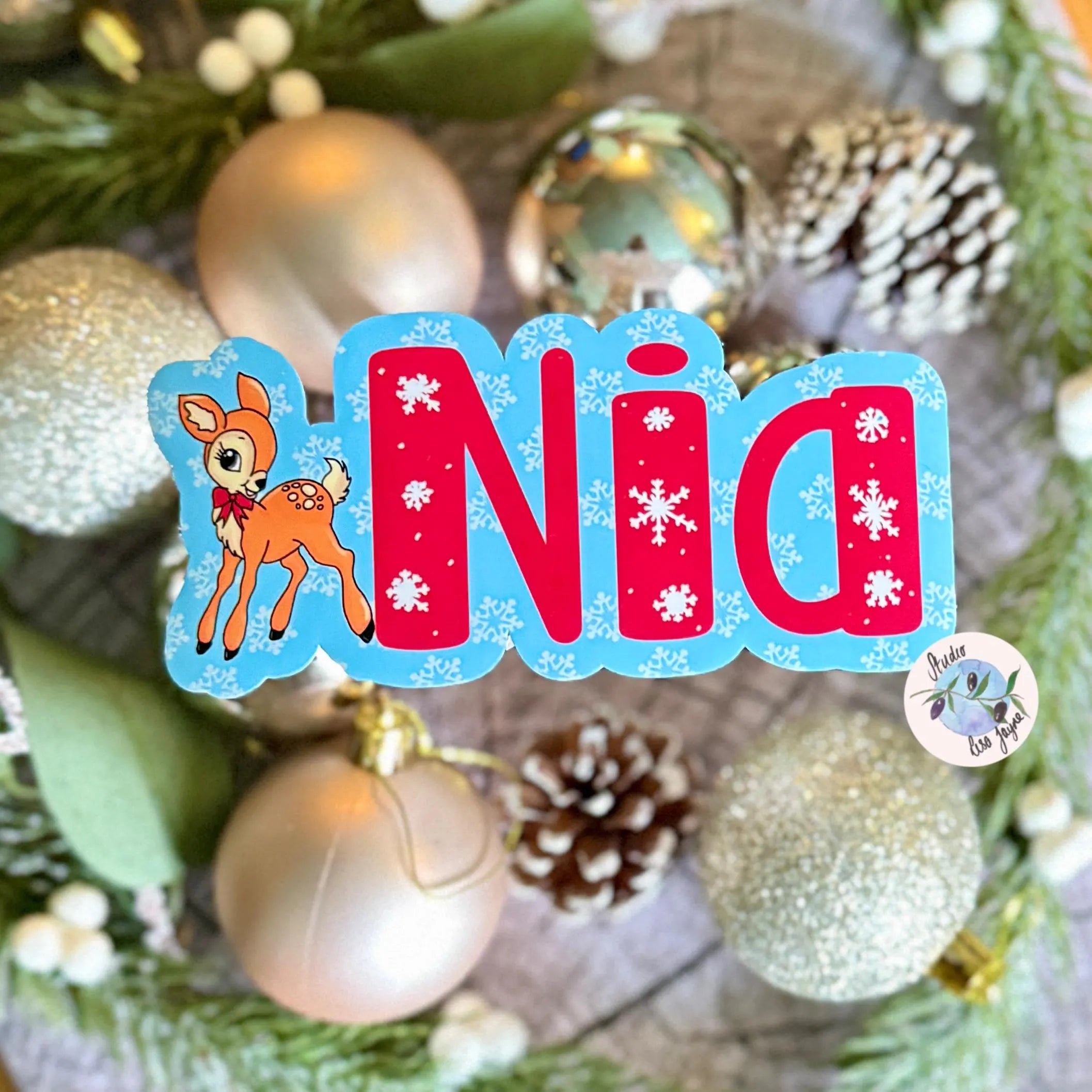 Decorative name vinyl sticker with 'Nia' and a deer design on a Christmas tree background.