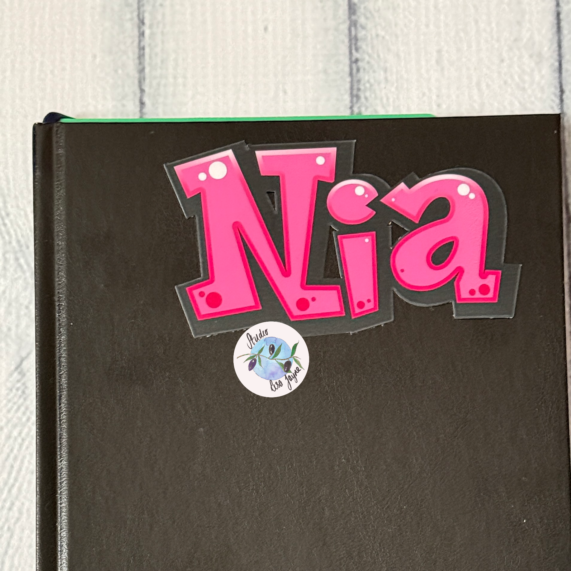 Comic Style Graffiti Personalised Waterproof Vinyl Name Sticker - Pink Nia sticker used to customise a business notebook