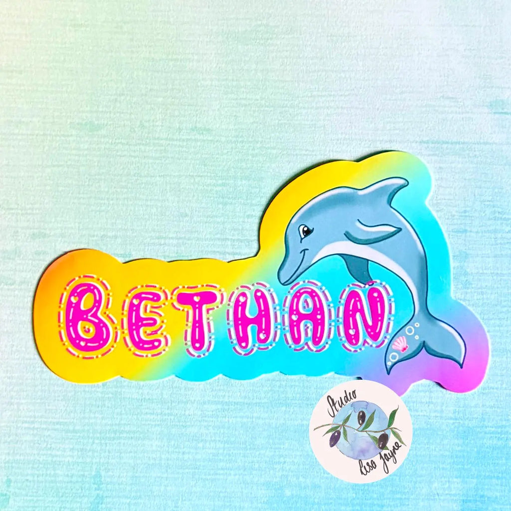 Colorful rainbow sticker with a dolphin and the name 'BETHAN' in pink qwerky text