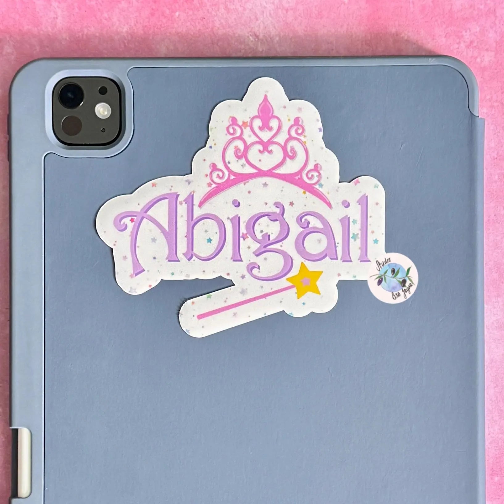 Blue tablet case with a decorative sticker featuring pink and purple fairy princess name sticker with the name 'Abigail' on a pink background