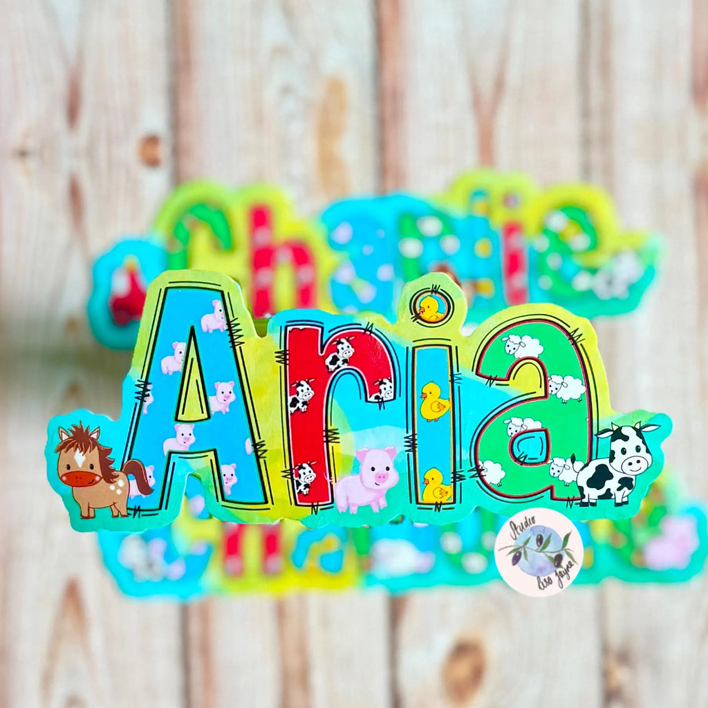 Colorful name decor with 'Aria' and farm animal illustrated name sticker on a wooden background