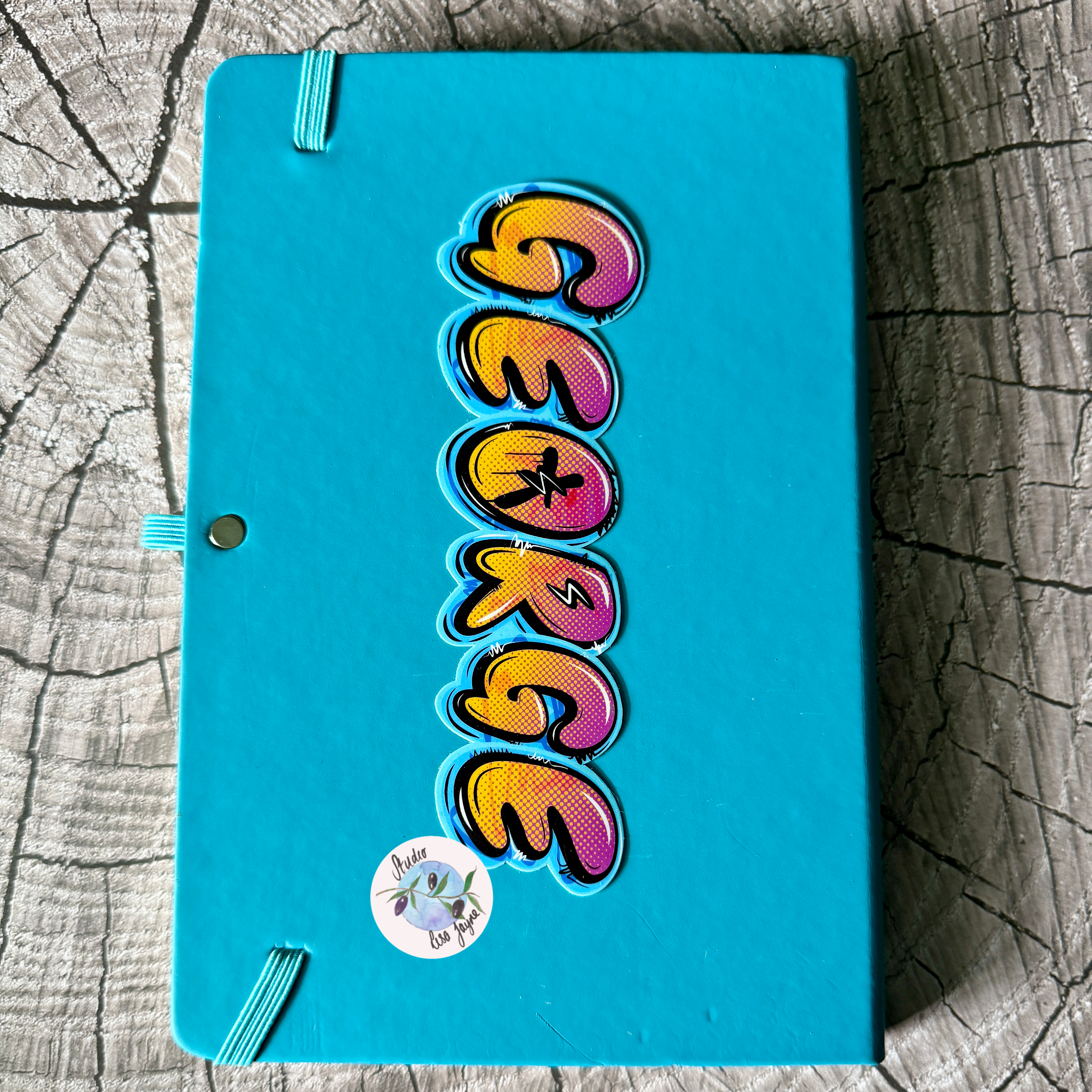 Graffiti Personalised Waterproof Vinyl Lightning Bolt Name Sticker Orange and Pink Stippled gradient on light blue Backdrop.   Customised notebook