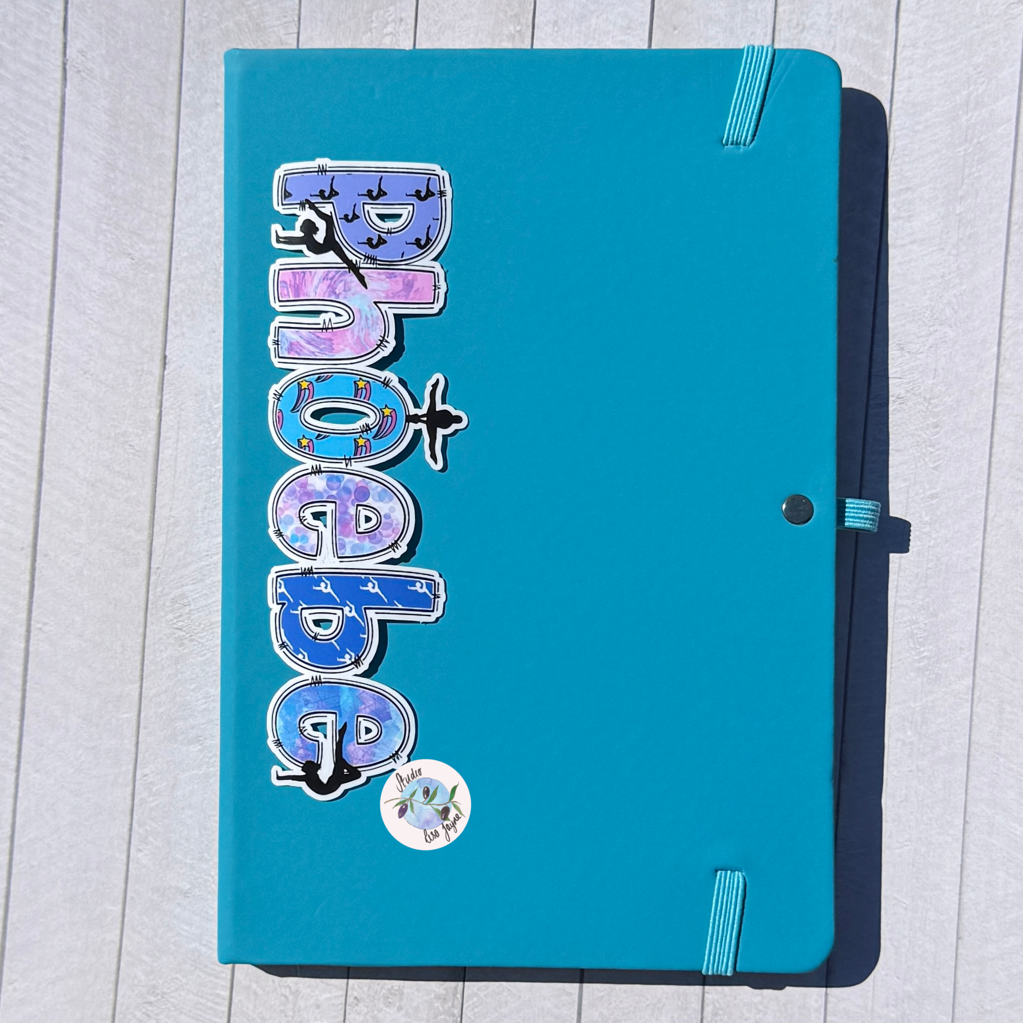 Gymnastics Name Sticker Applied to a notebook.  Waterproof personalised sports label for diary journal