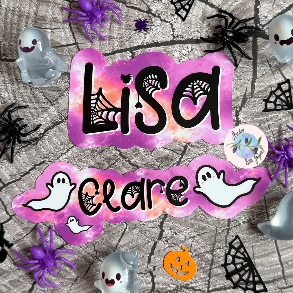 Halloween-themed pink name sticker display with 'Lisa Clare' on a spider web background.