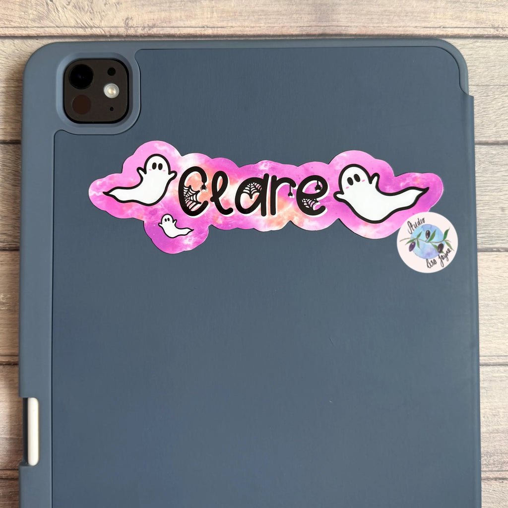 iPad table case with 'Clare' sticker in a pink ghost design on a wooden surface