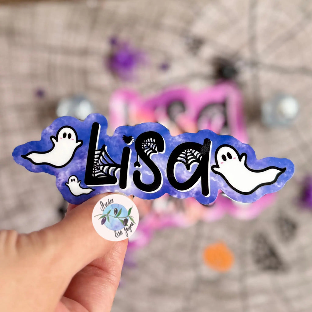 Sticker with 'Lisa' and ghost design sticker in purple held by a hand against a blurred background