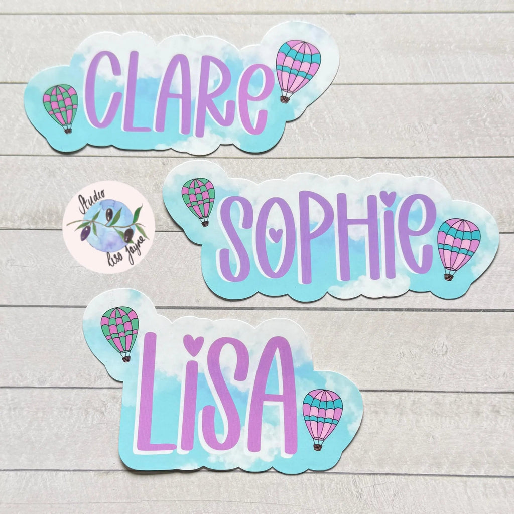 Stickers with names 'Clare', 'Sophie', and 'Lisa' on a wooden surface