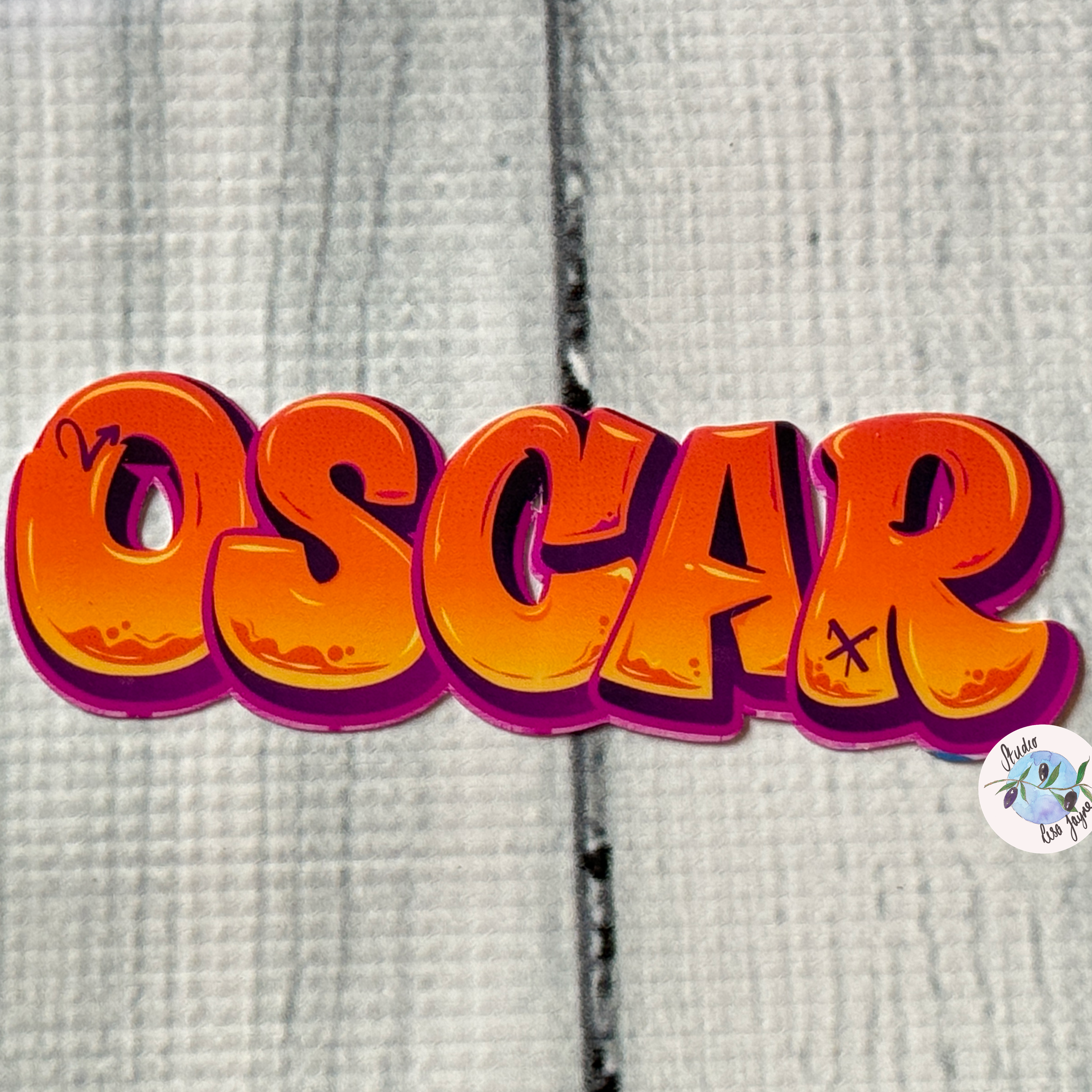 Orange graffiti name sticker on a whitewash wood backdrop