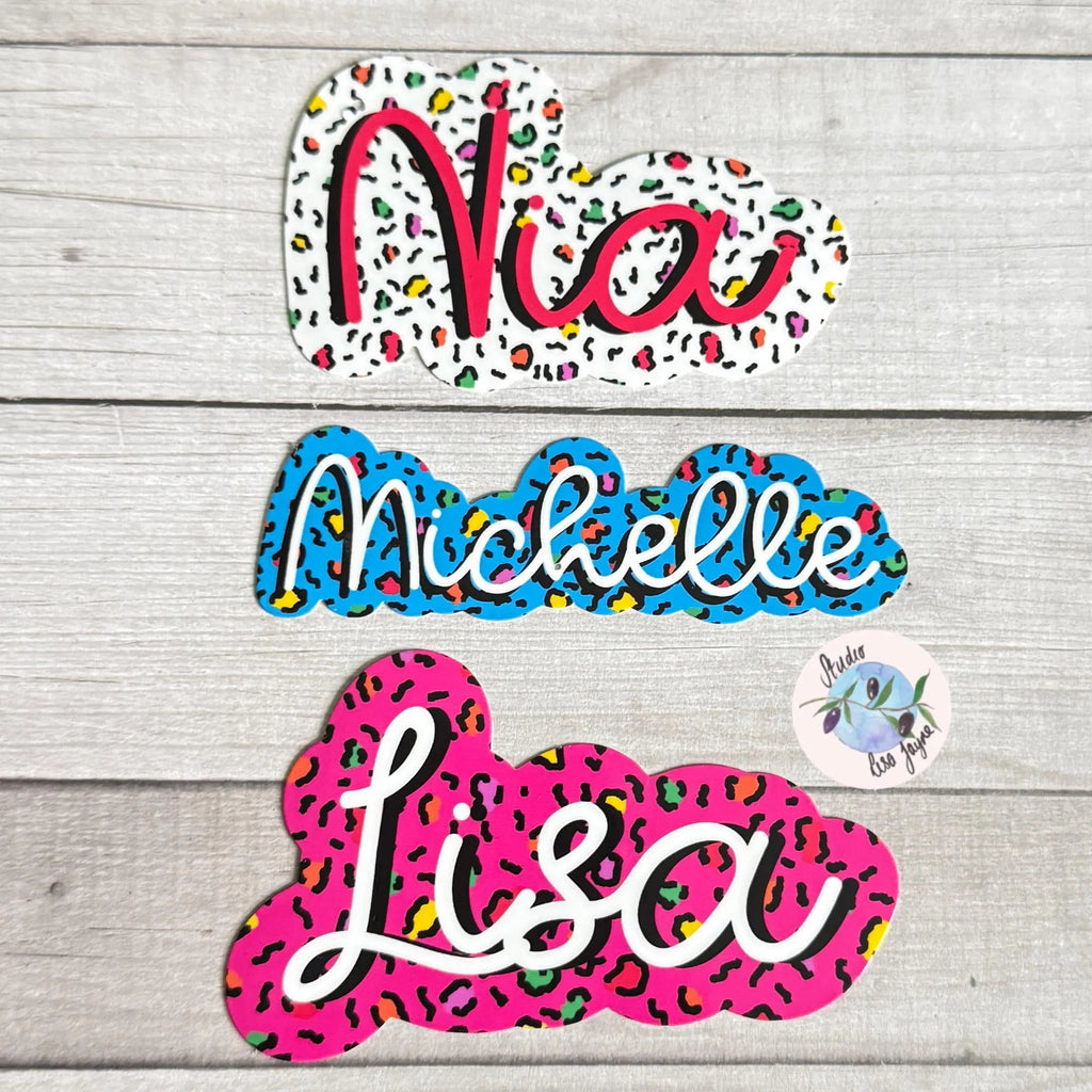 Colorful name leopard print stickers on a wooden surface