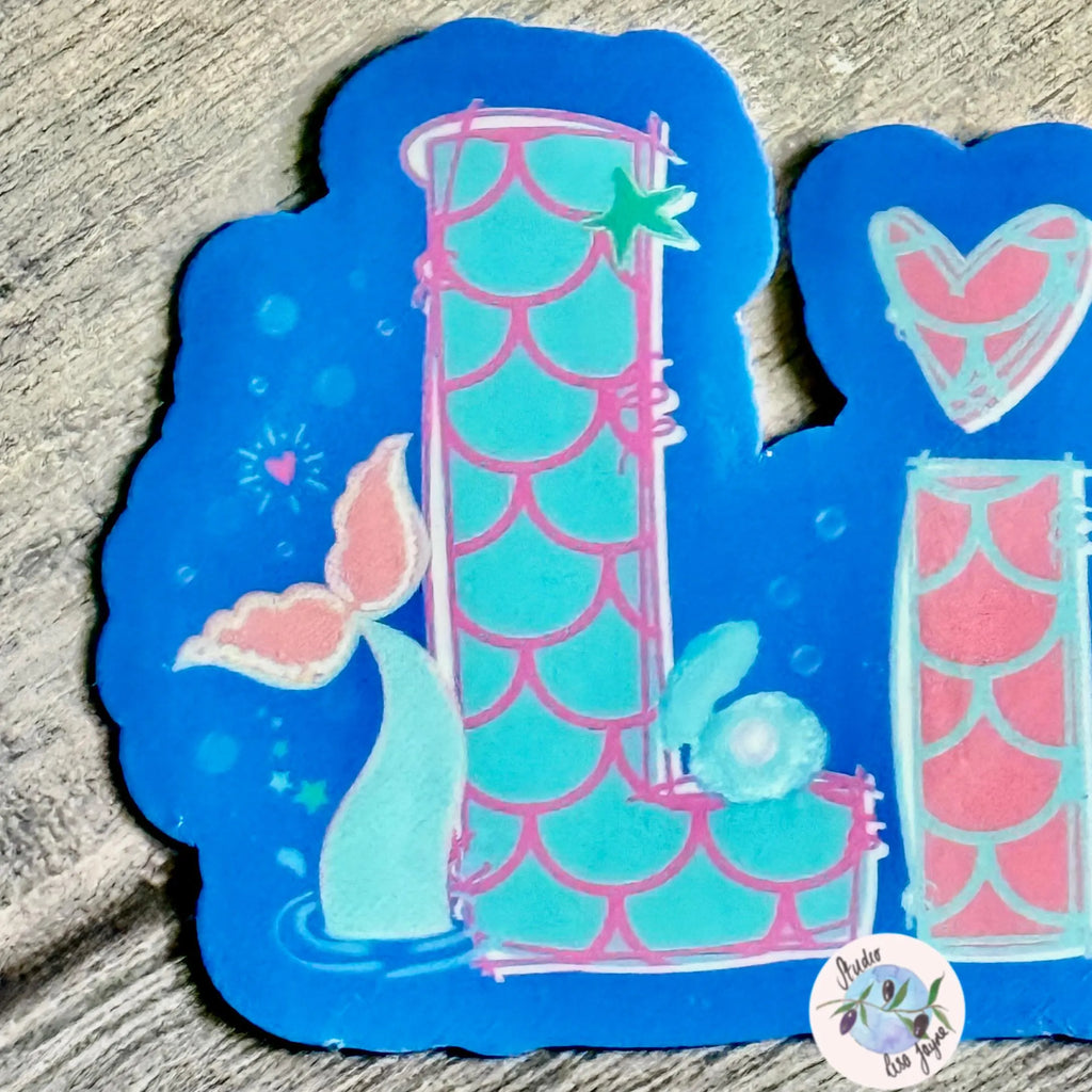 Mermaid-themed name sticker with blue and pink design closeup on mermaid tail, scale design and clam shell