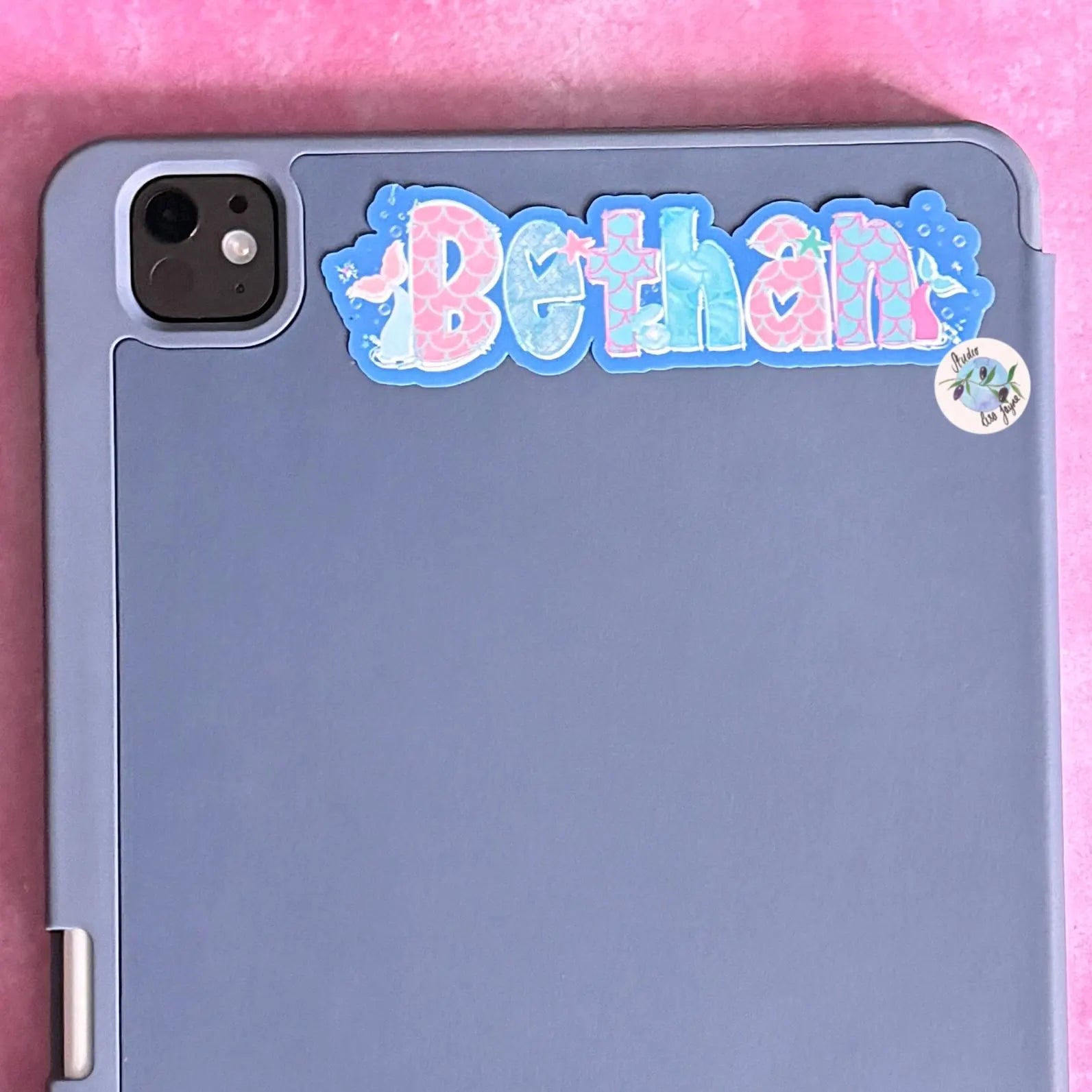 iPad Tablet case with a decorative 'Bethan' mermaid sticker on a pink background