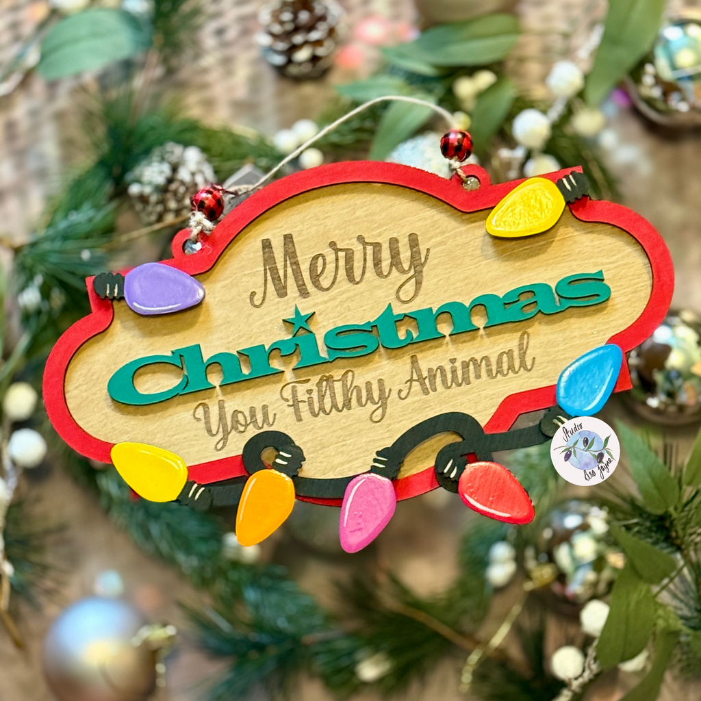 Decorative Christmas sign with colorful lights and text on a tree.