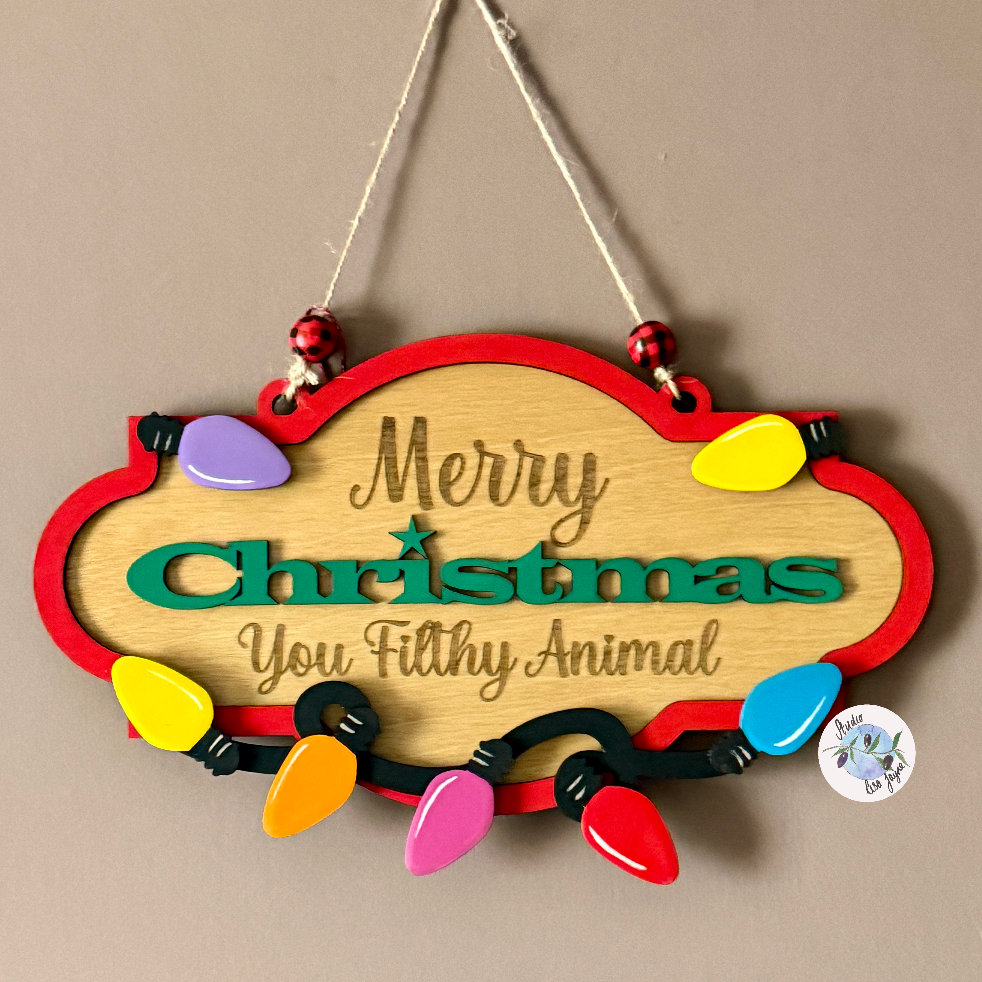 Decorative Christmas sign with colorful lights and text on a beige background