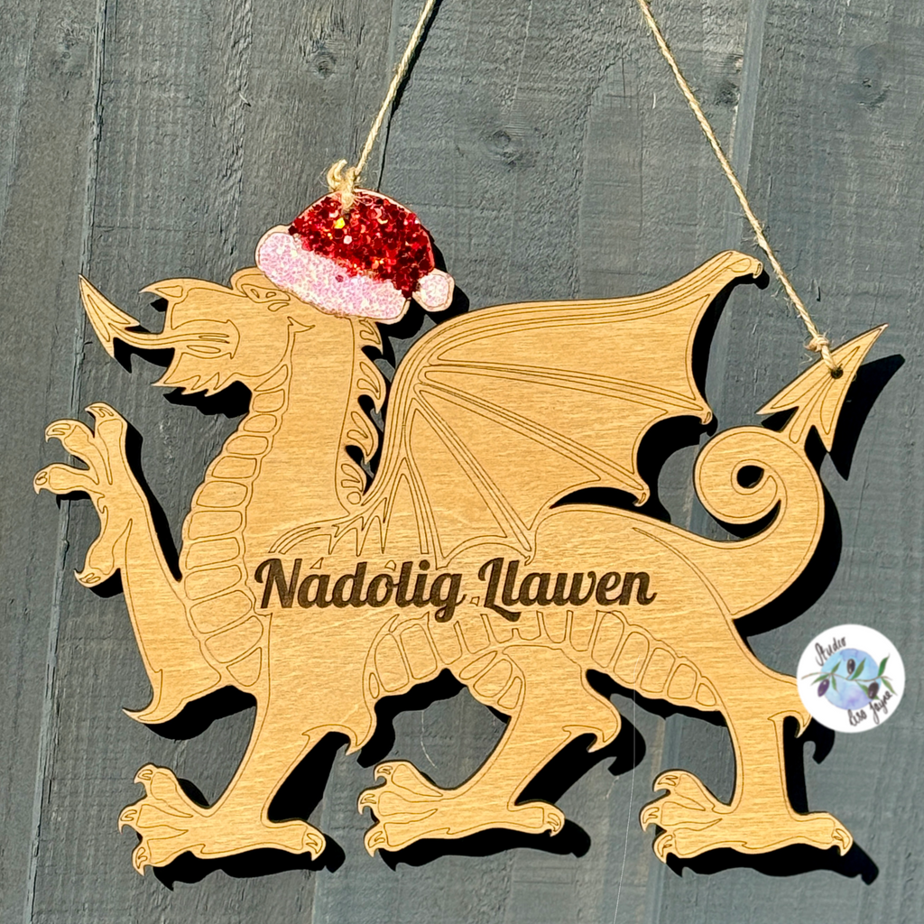Wooden Welsh Christmas dragon hanging sign with a Santa hat on a wooden background