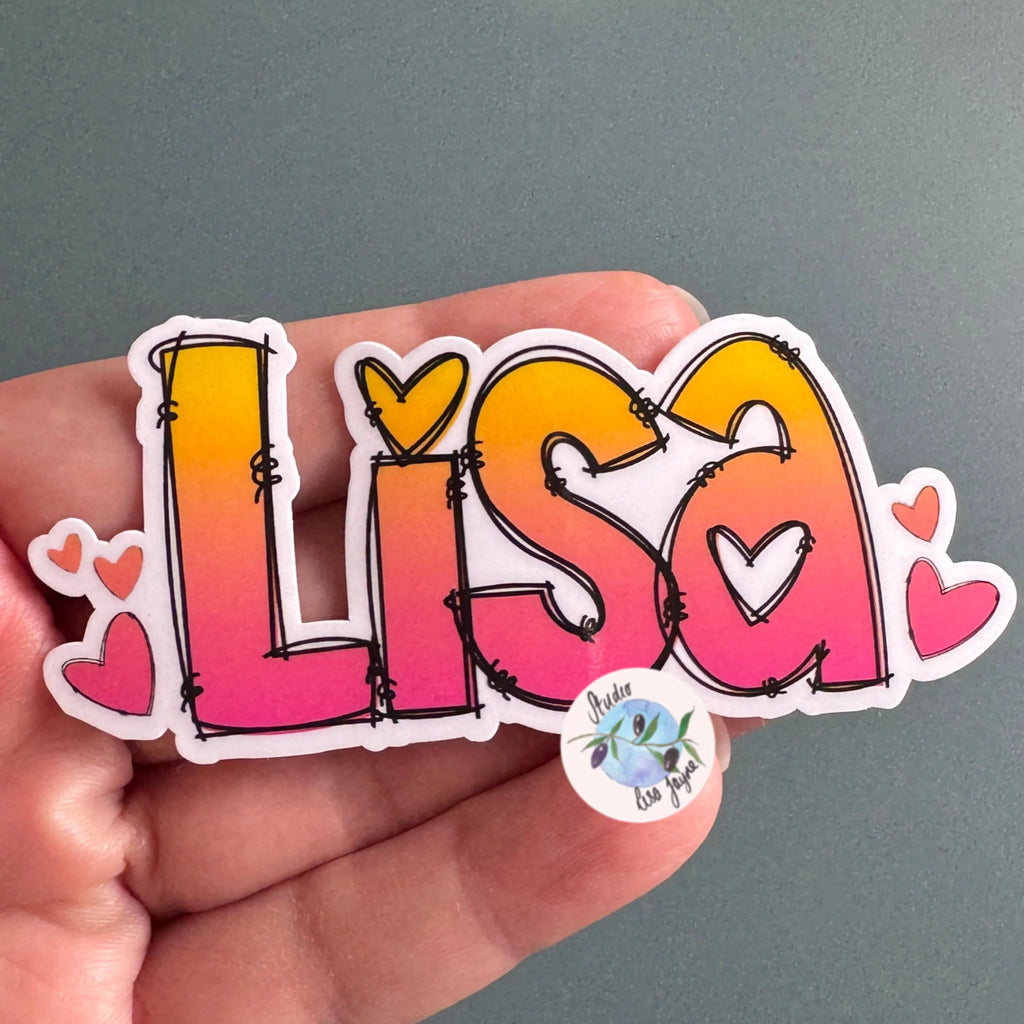 Hand holding a colorful 'Lisa' sticker with heart designs on a gray background