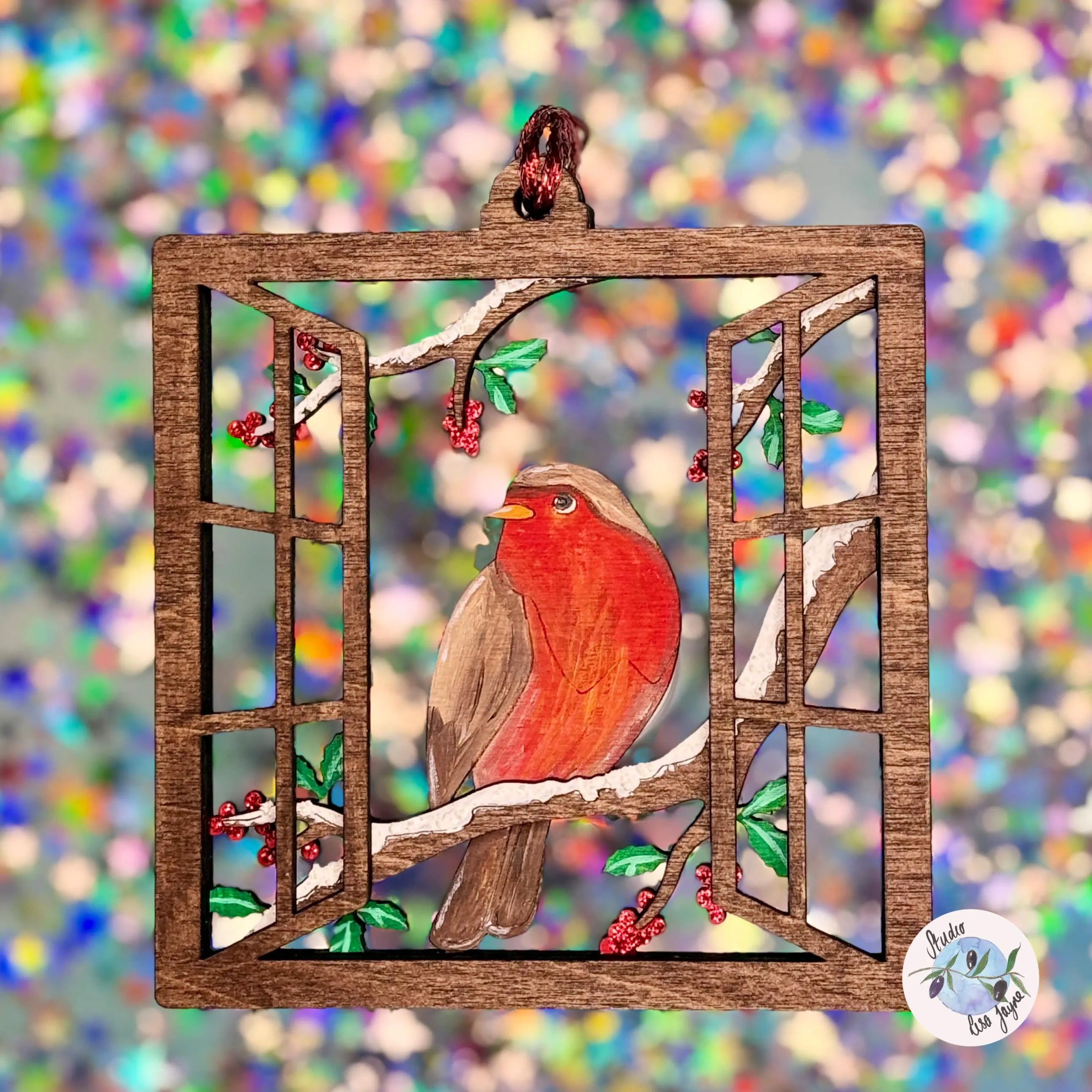 Decorative window frame Christmas Tree decoration with a red robin on a colourful glitter blurred background