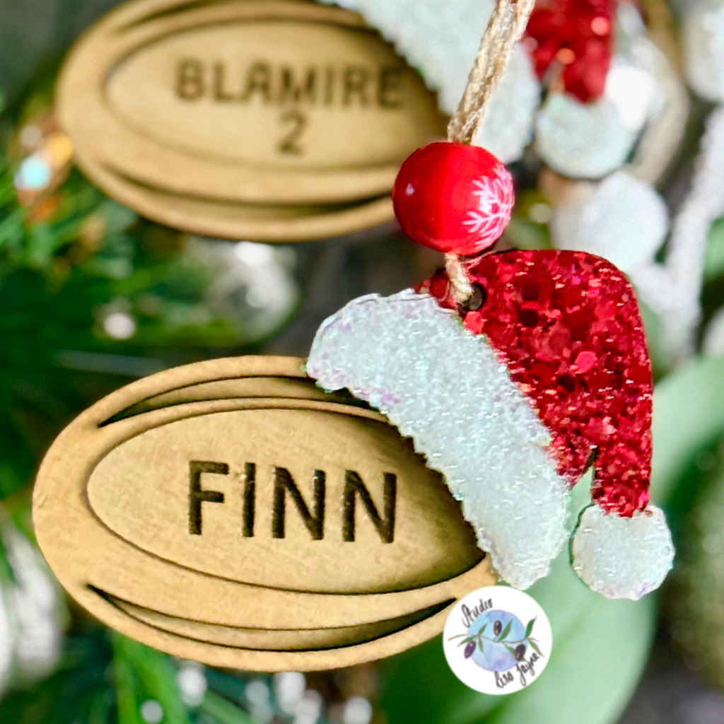 Personalised rugby Christmas decoration with the name Finn engraved and a glitter Santa hat