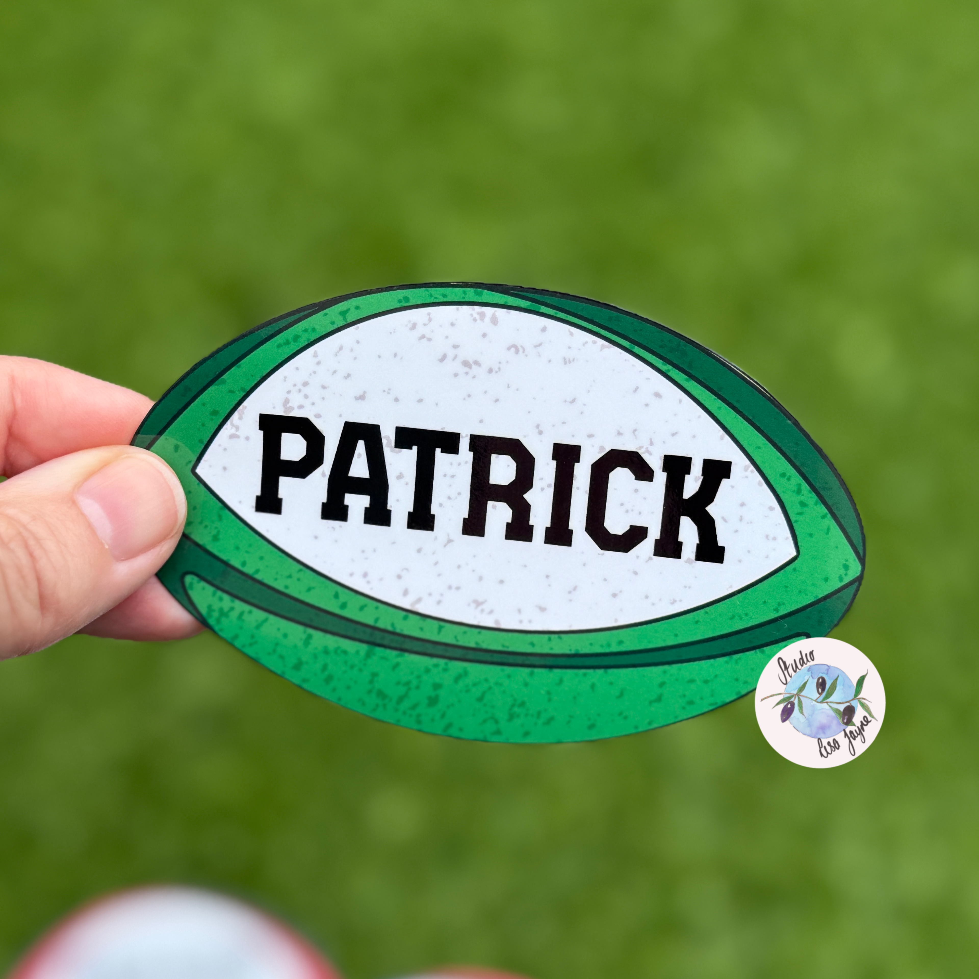 Irish rugby ball themed sticker in Green and white with 'PATRICK' text held against a green background