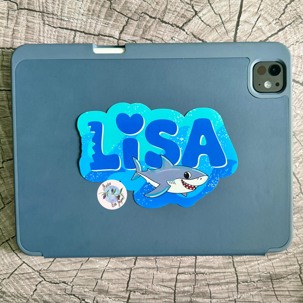 Blue tablet case with 'LISA' and a shark custom design Name decal on a wooden surface