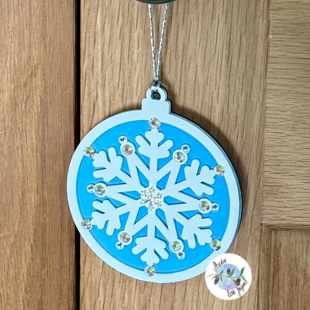 White and blue Christmas Tree snowflake ornament with rhinestones on a wooden surface