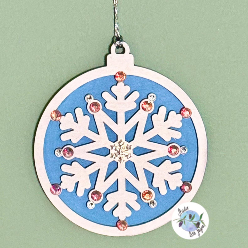 Decorative snowflake ornament with gemstones on a light green background