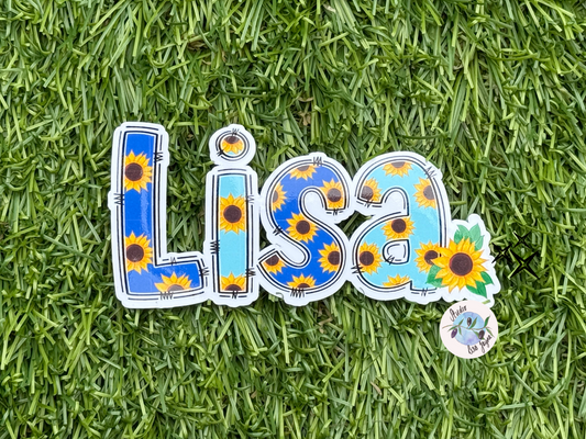 Sticker with 'LISA' and sunflower design on grass